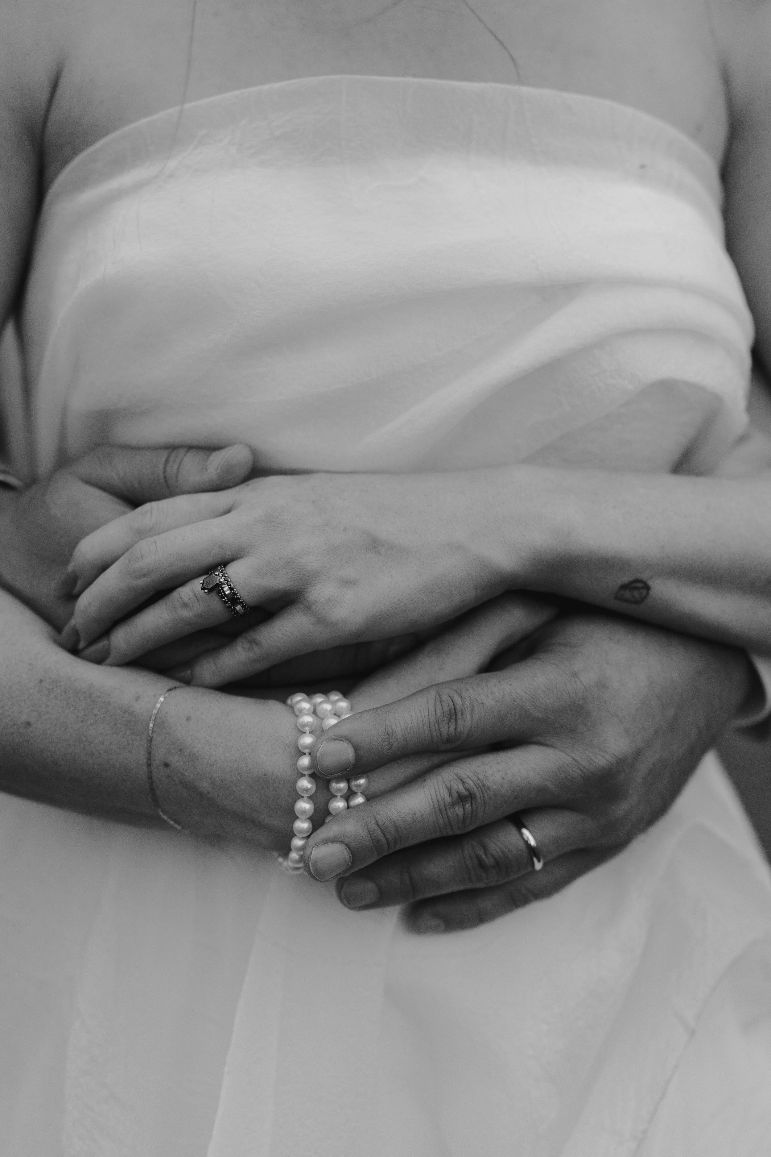 closeup of groom hugging bride from behind
