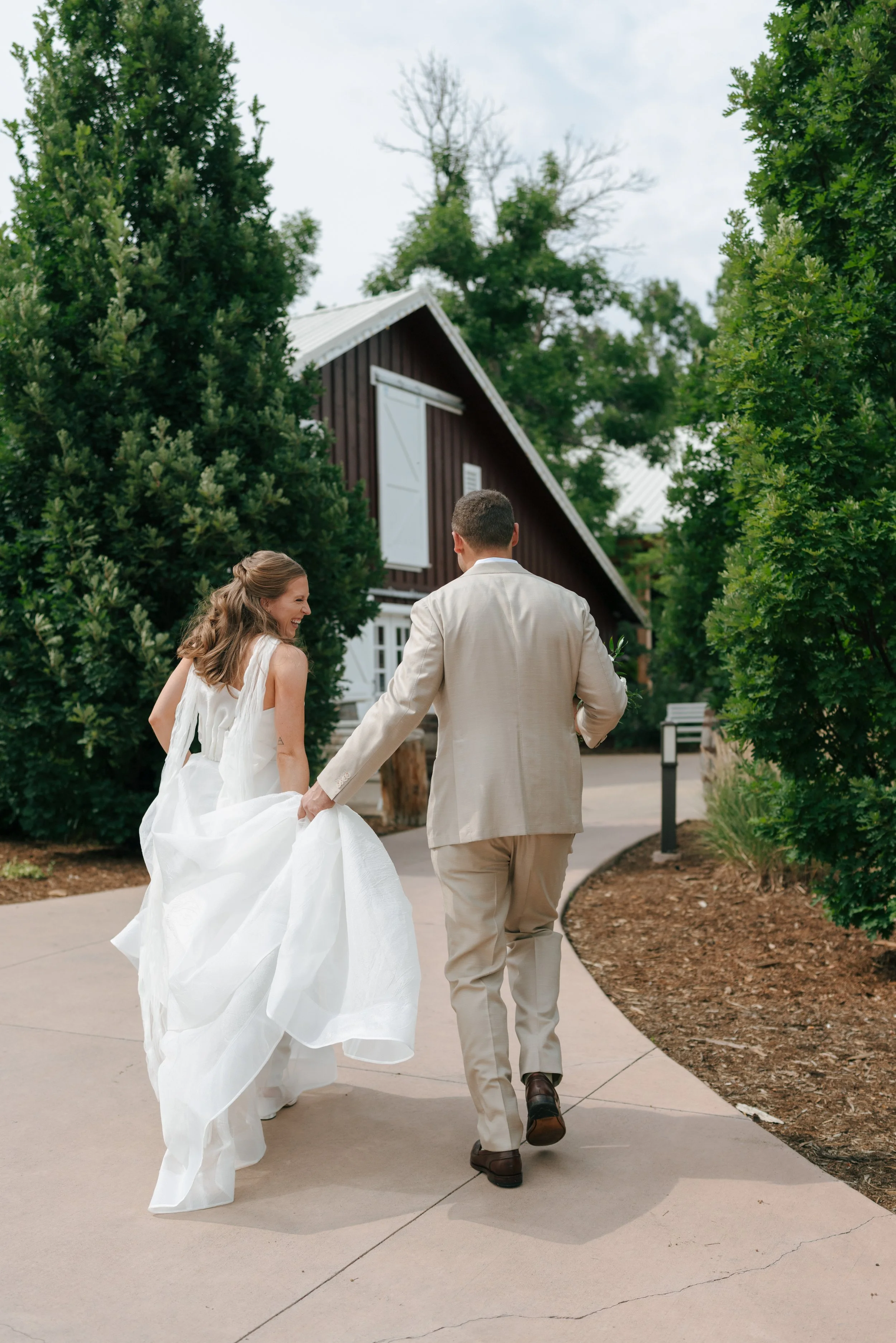 bride and groom walking to a barn 