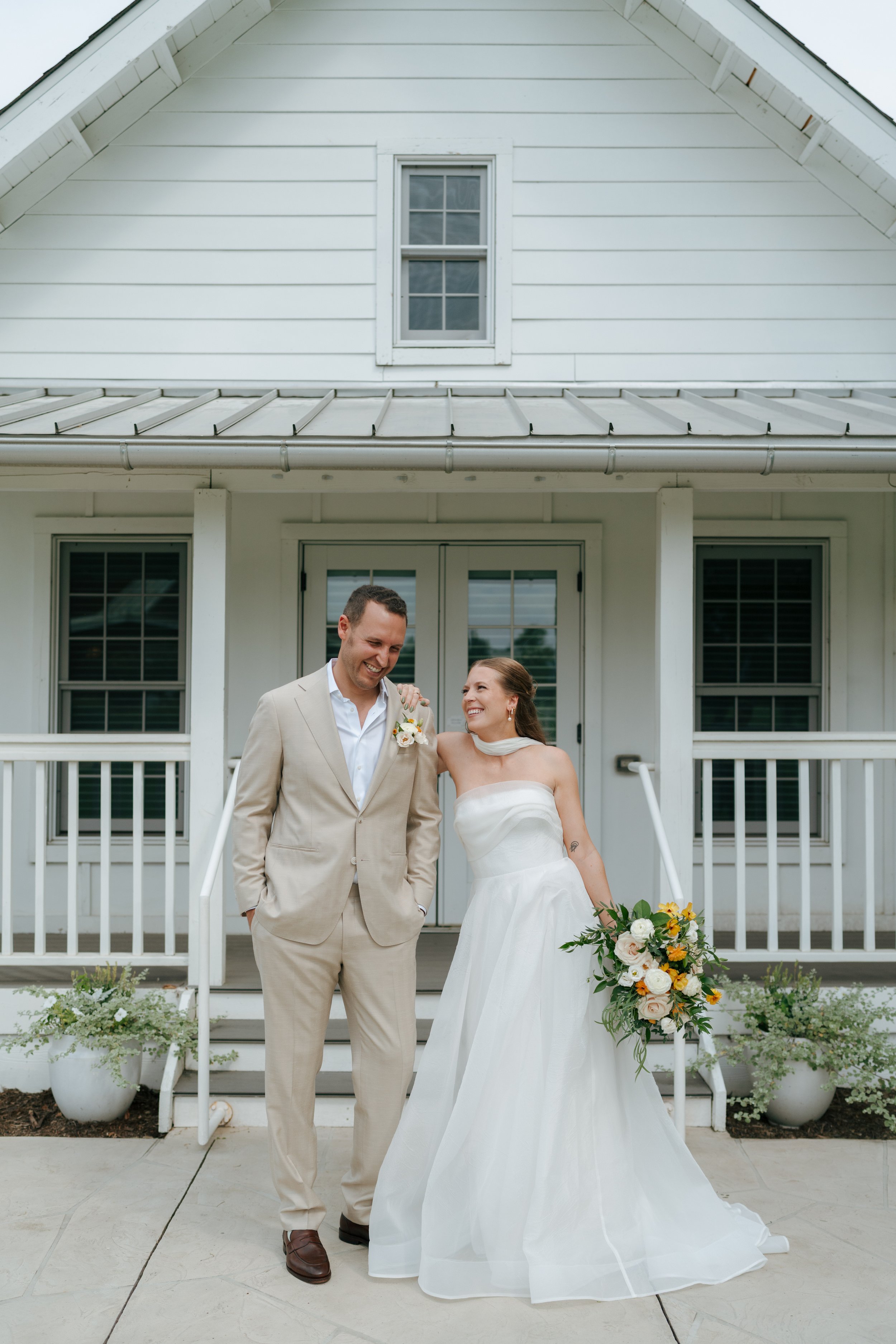 bride and groom posing in front of the bridal cottage