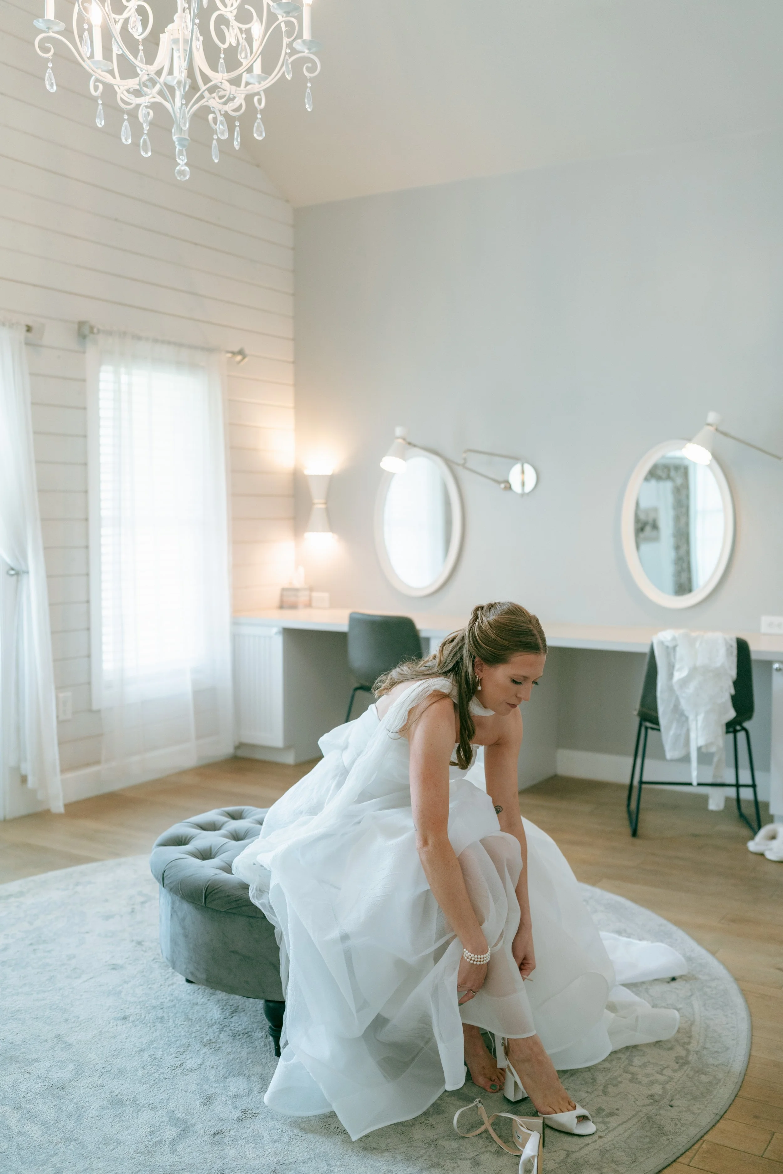 bride putting on her shoes in the bridal cottage 