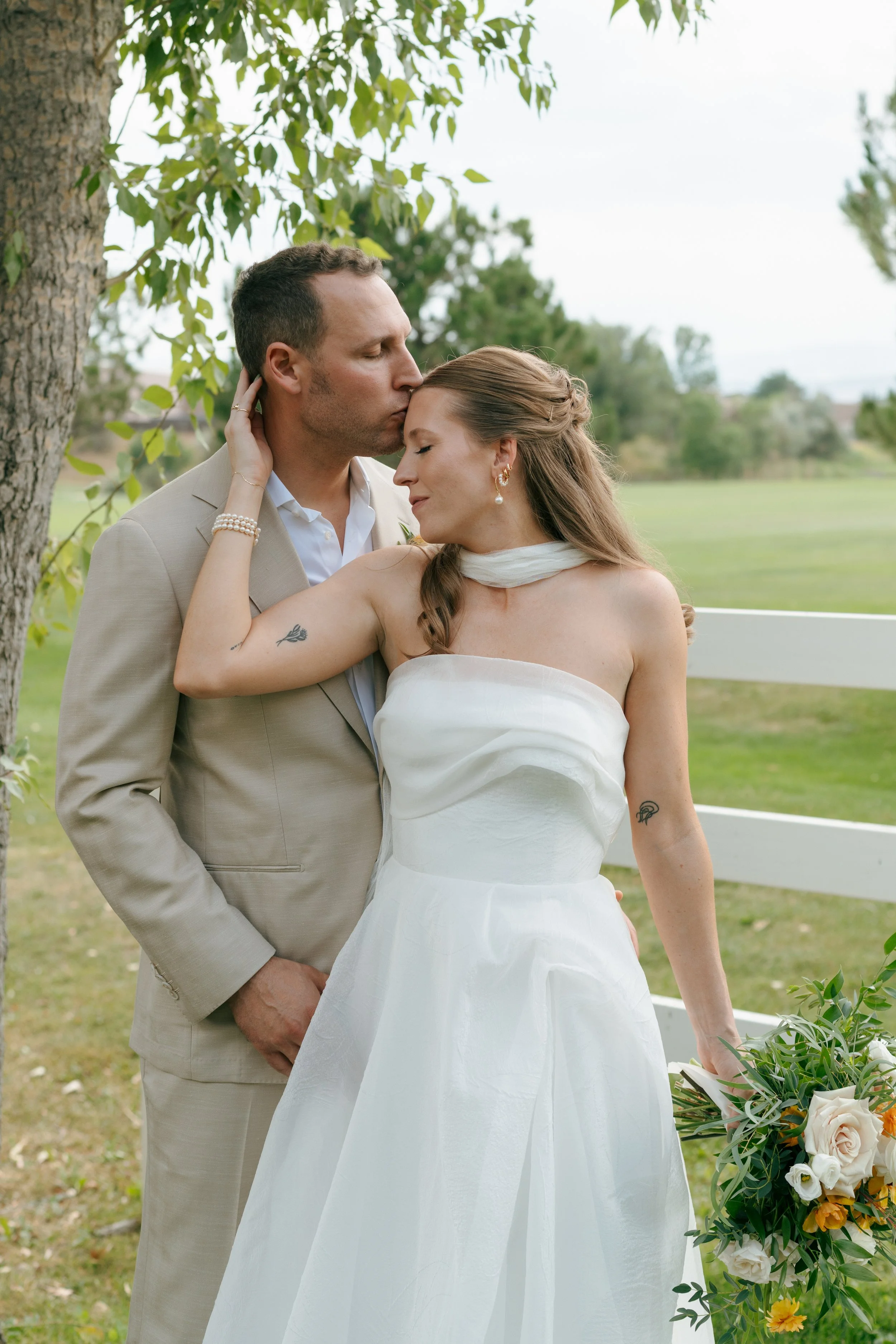 groom kissing the bride on her forehead 