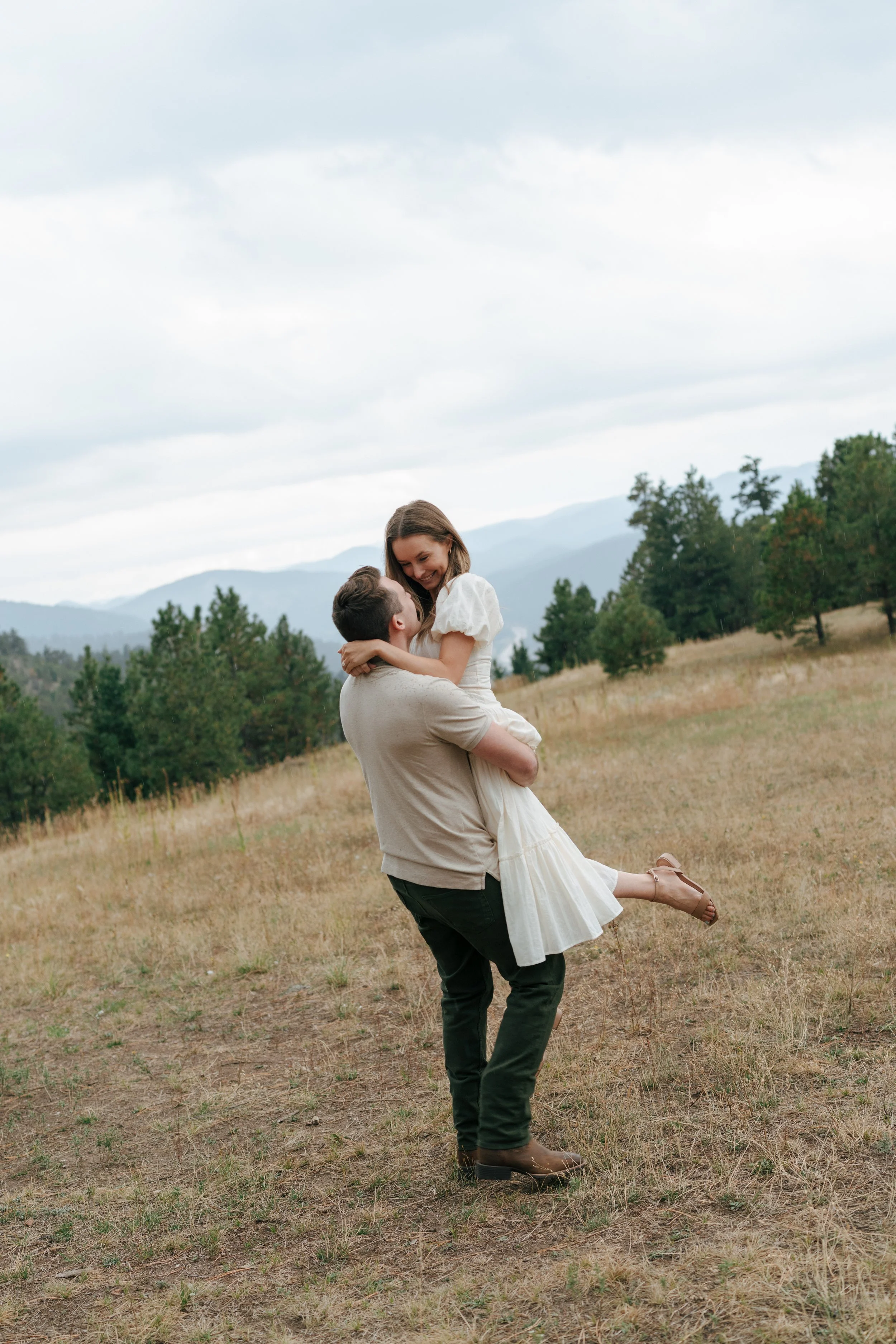 a man spinning a woman during their engagement photoshoot