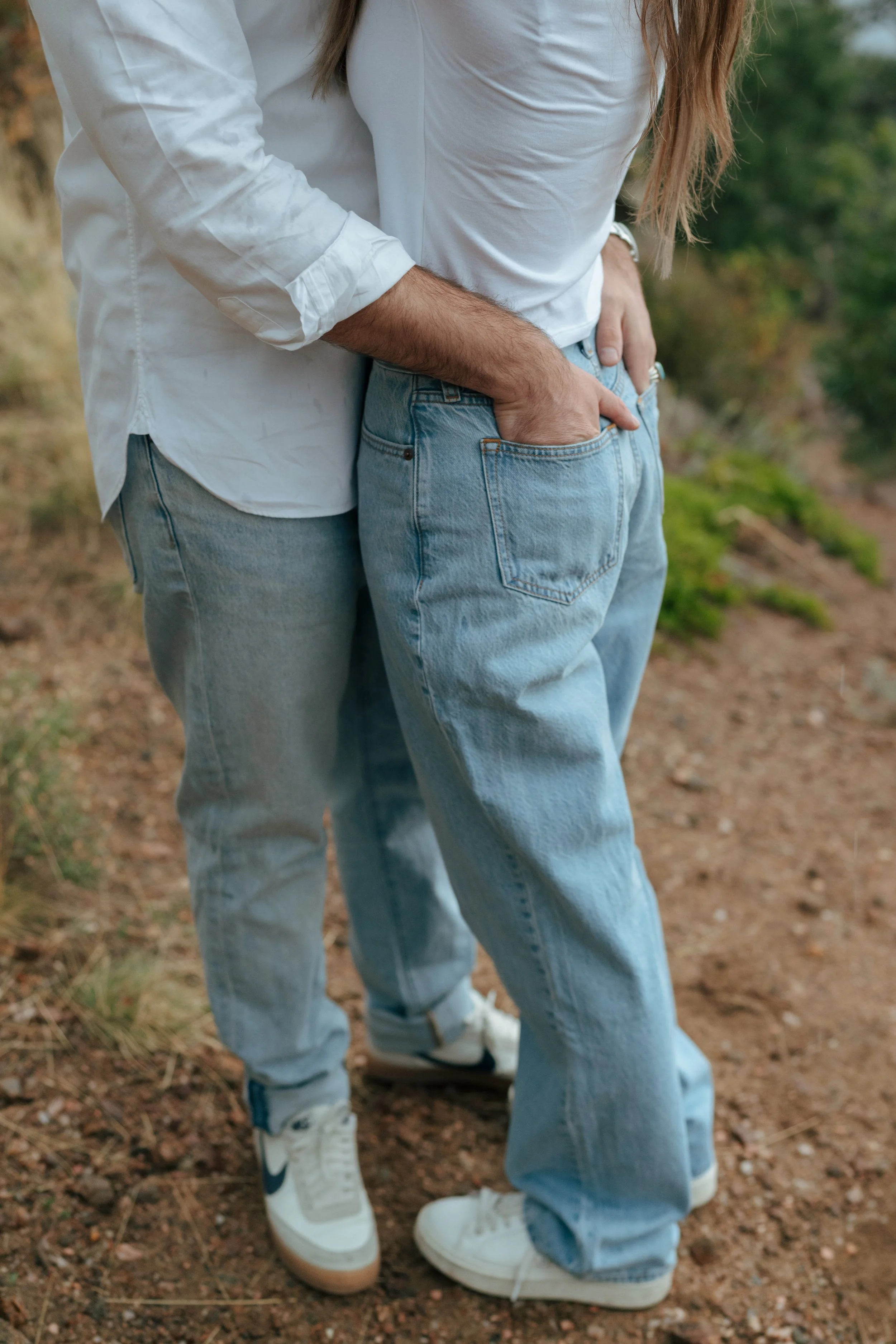 a man with his hands in a woman's back pockets during their cinematic engagement photoshoot