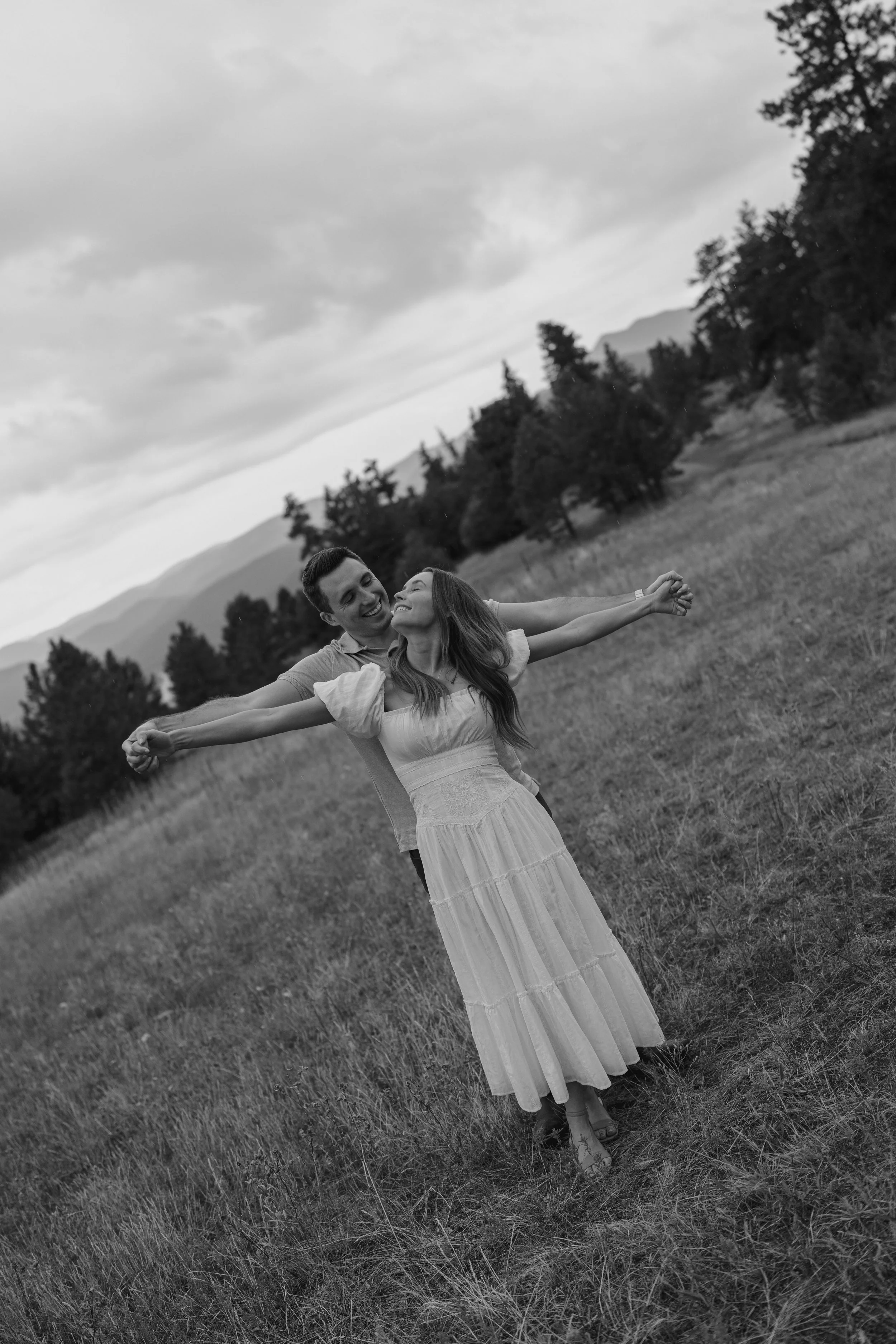 a man standing behind a woman with their arms out stretched together 