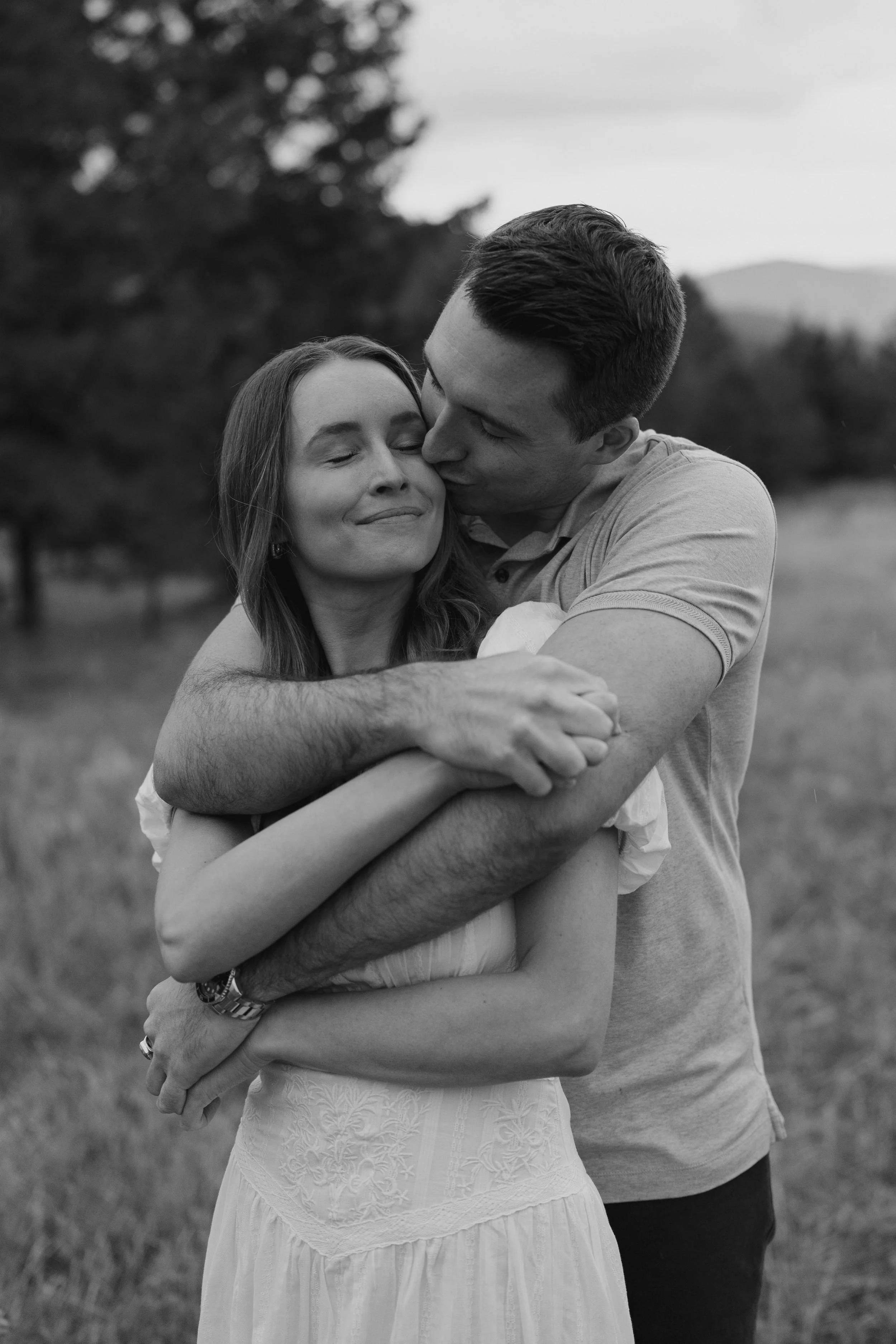 a man hugging a woman from behind during their cinematic engagement photoshoot in CO