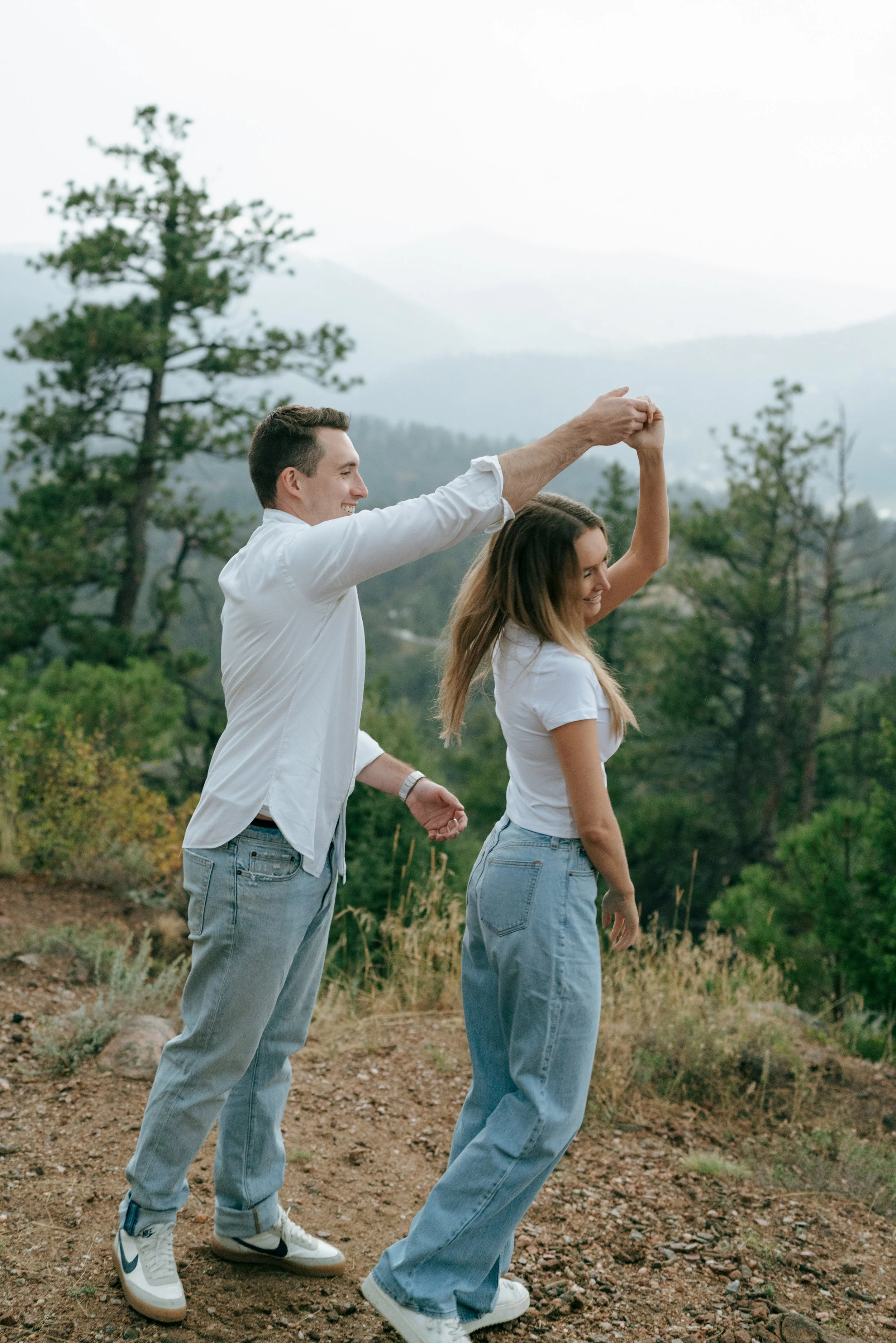 a couple dancing in the rain during their engagement photoshoot