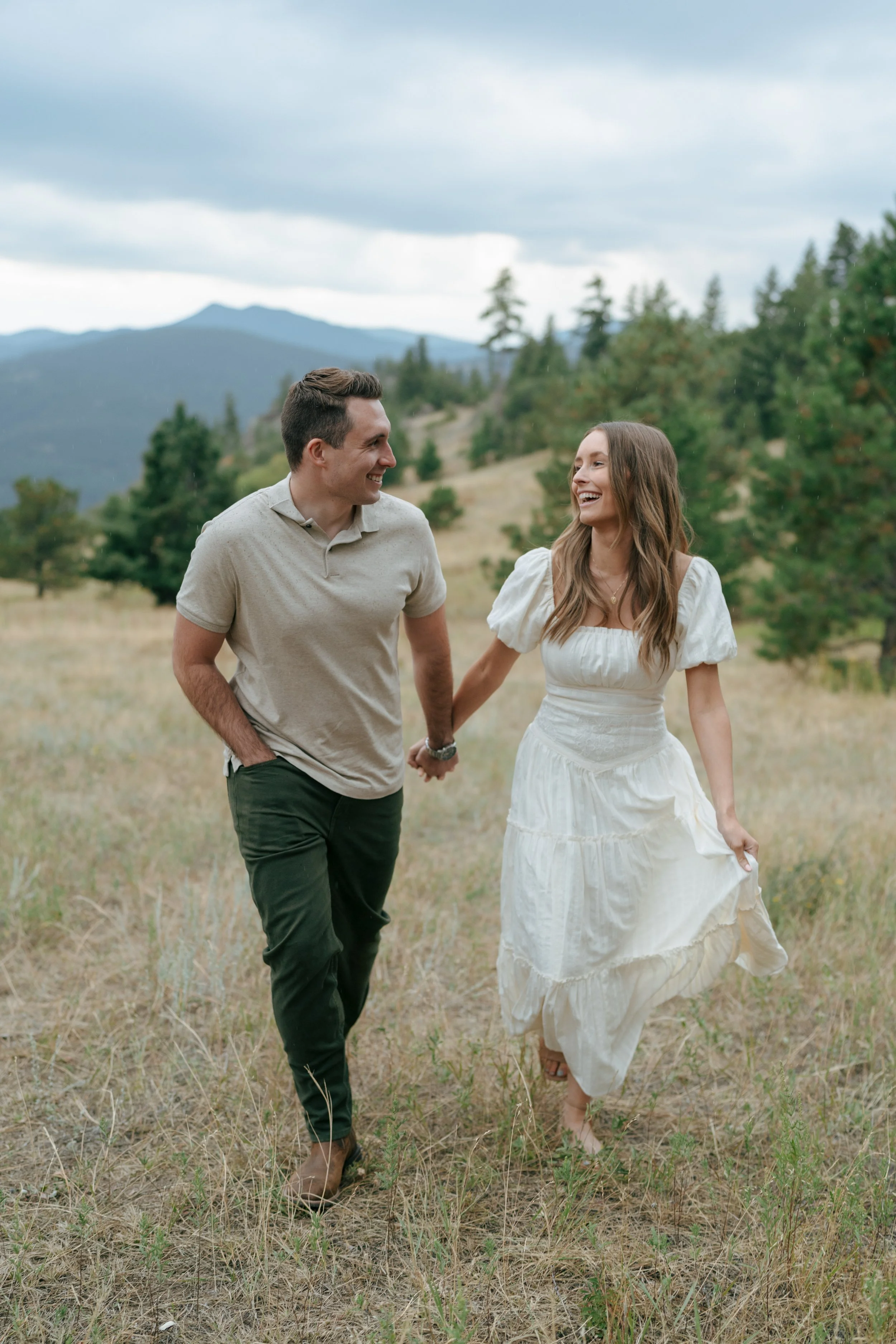 a couple holding hands and smiling during their outdoor engagement photoshoot
