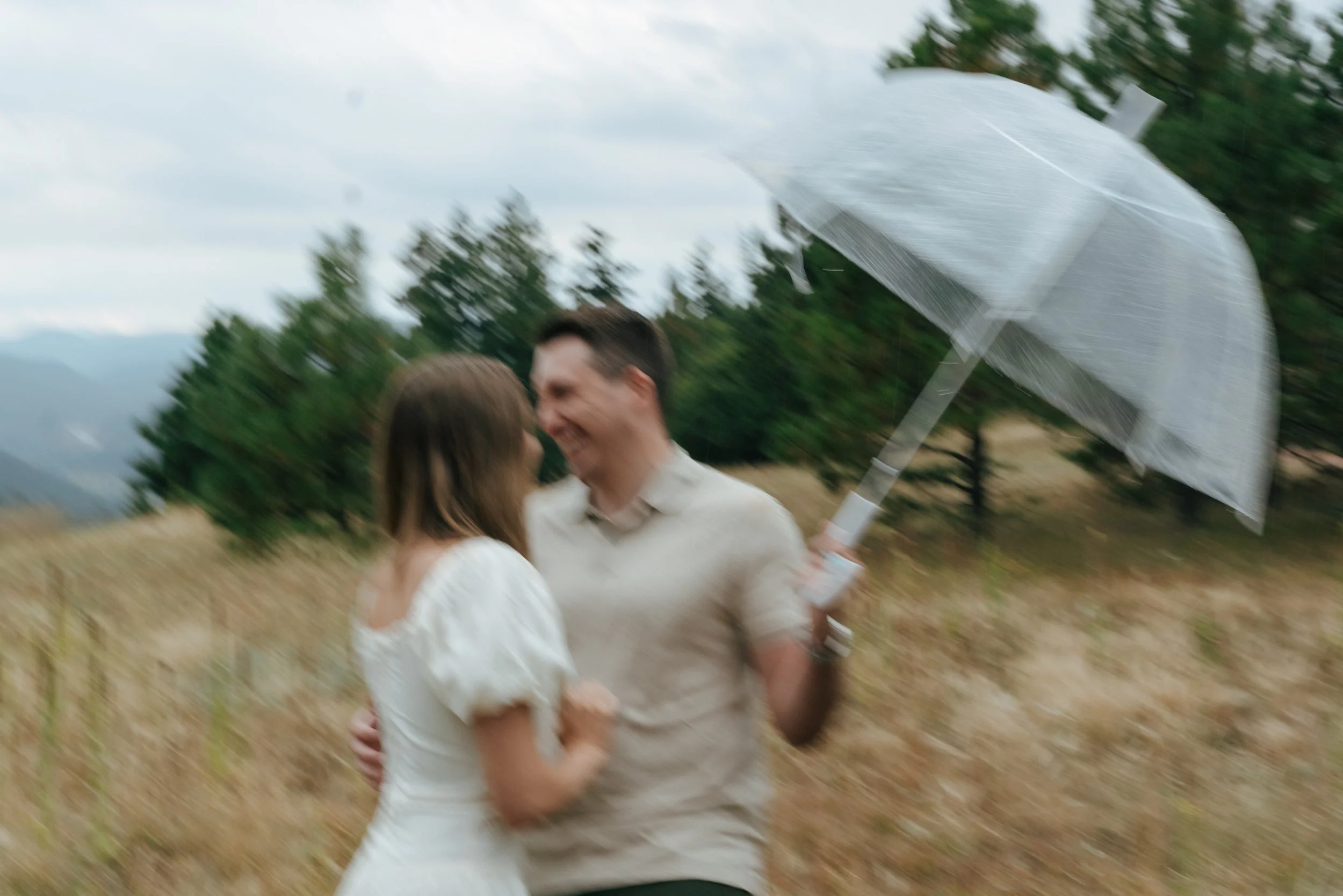 a blurry cinematic engagement photoshoot of a couple in the rain