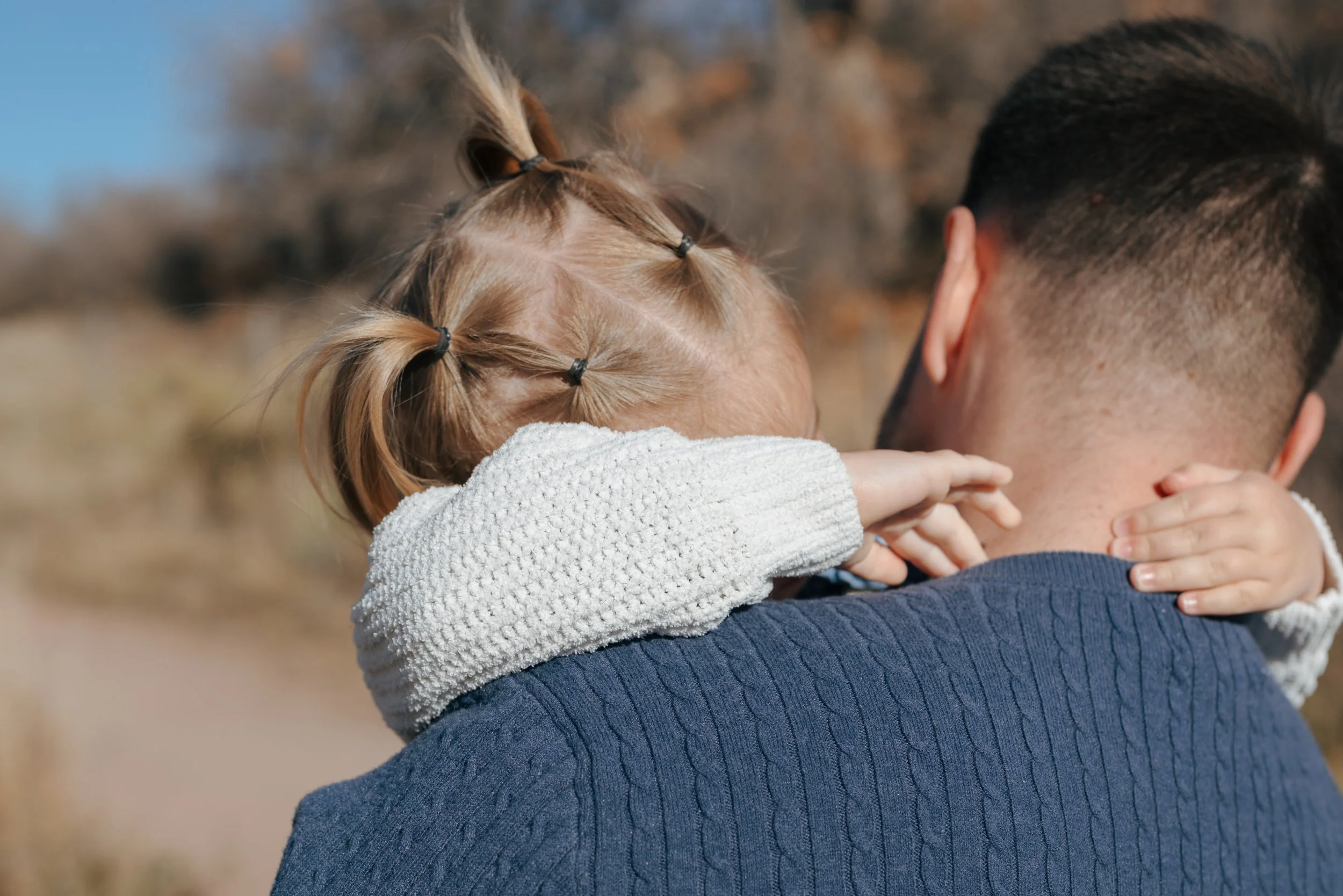 a dad holding his daughter during a family photo session in CO