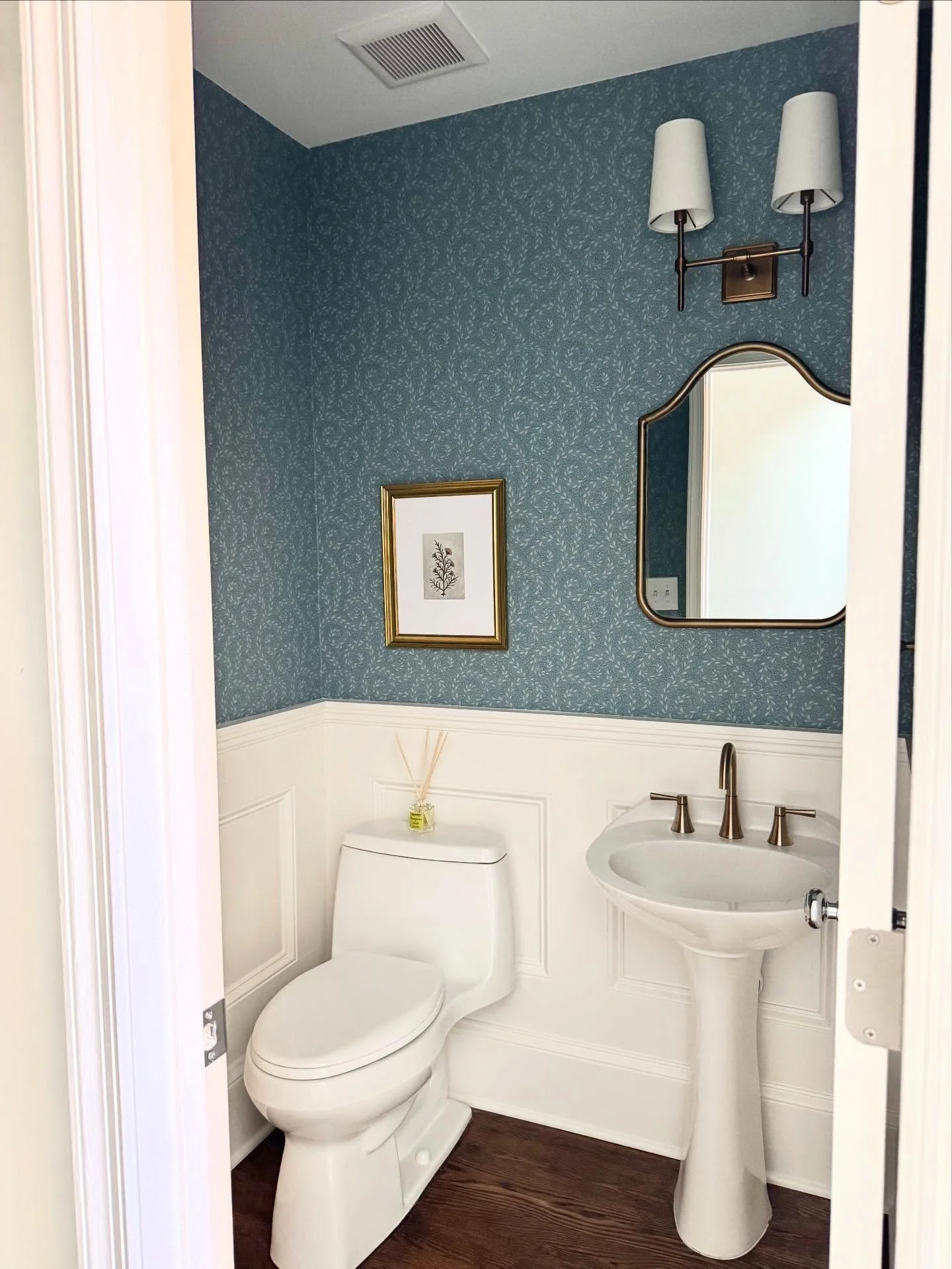 This Powder Room just turned out stunning! We added the wainscoting which really elevated the space, new mirror, light, hardware and wallpaper of course!
