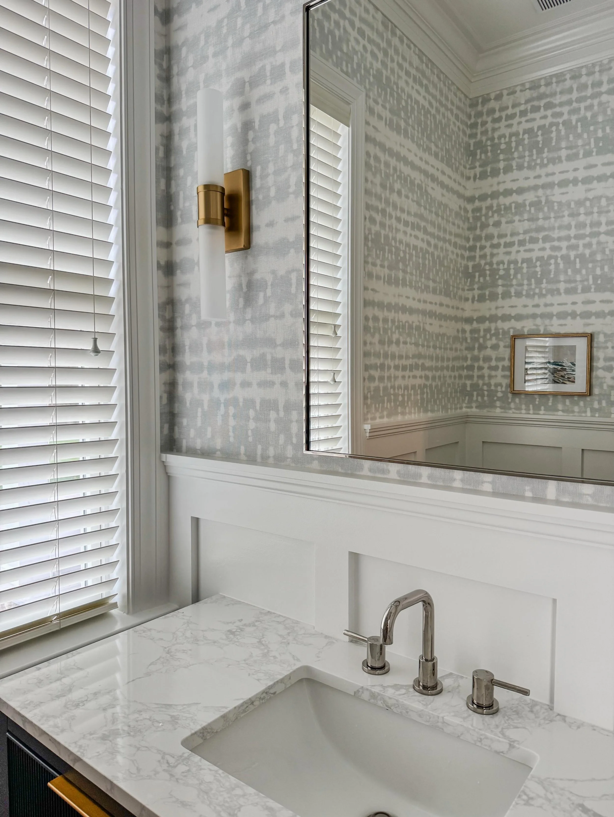 Beautiful wainscoting, fun wallpaper, and quality finishes. What more could a Powder Room need?