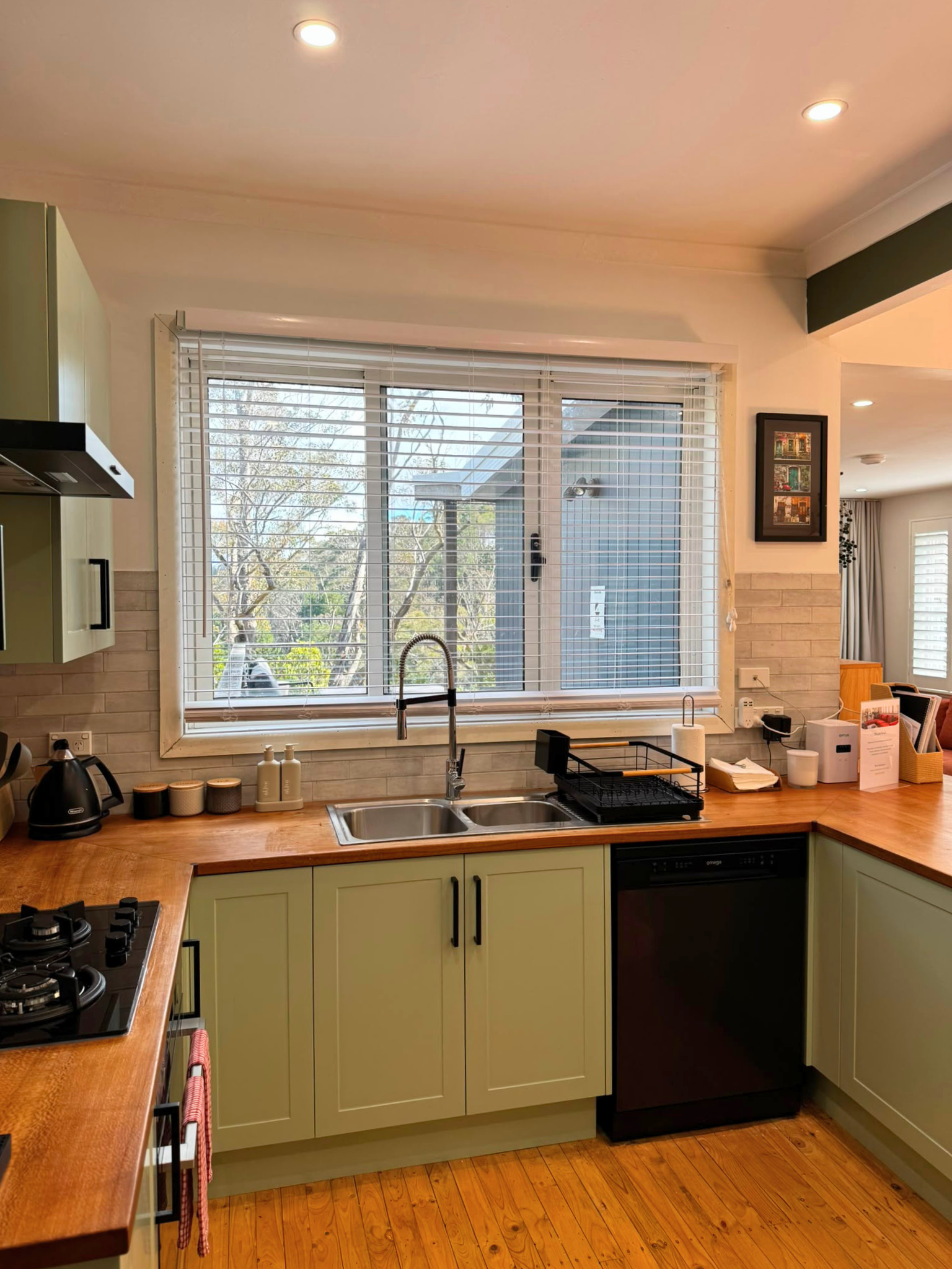 Bright kitchen with dishwasher, large sink, generous bench space and bushland views at Katoomba Falls Cottage.