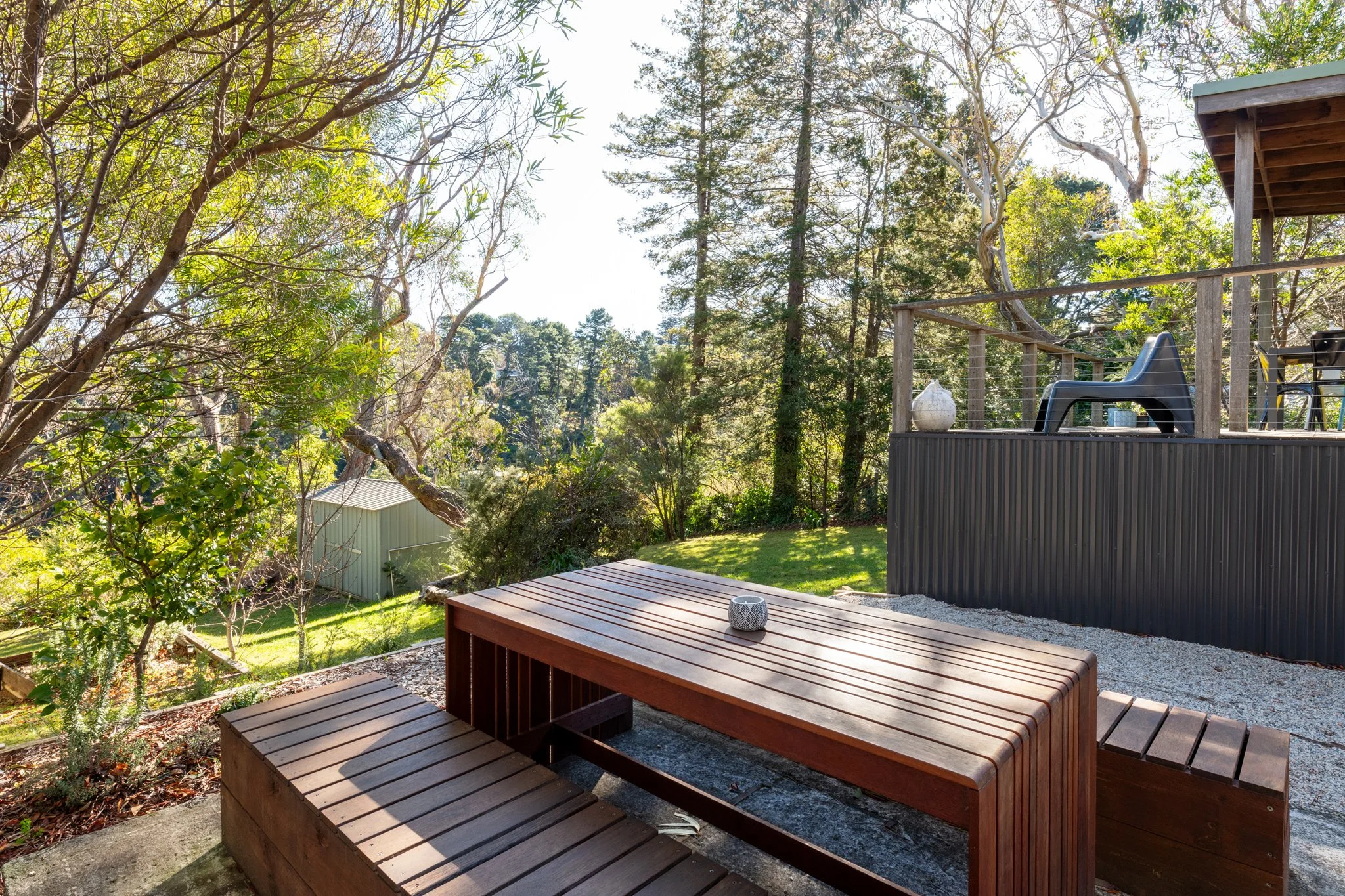 Outdoor seating area at Katoomba holiday cottage with timber picnic table, garden setting and bushland views in the Blue Mountains.