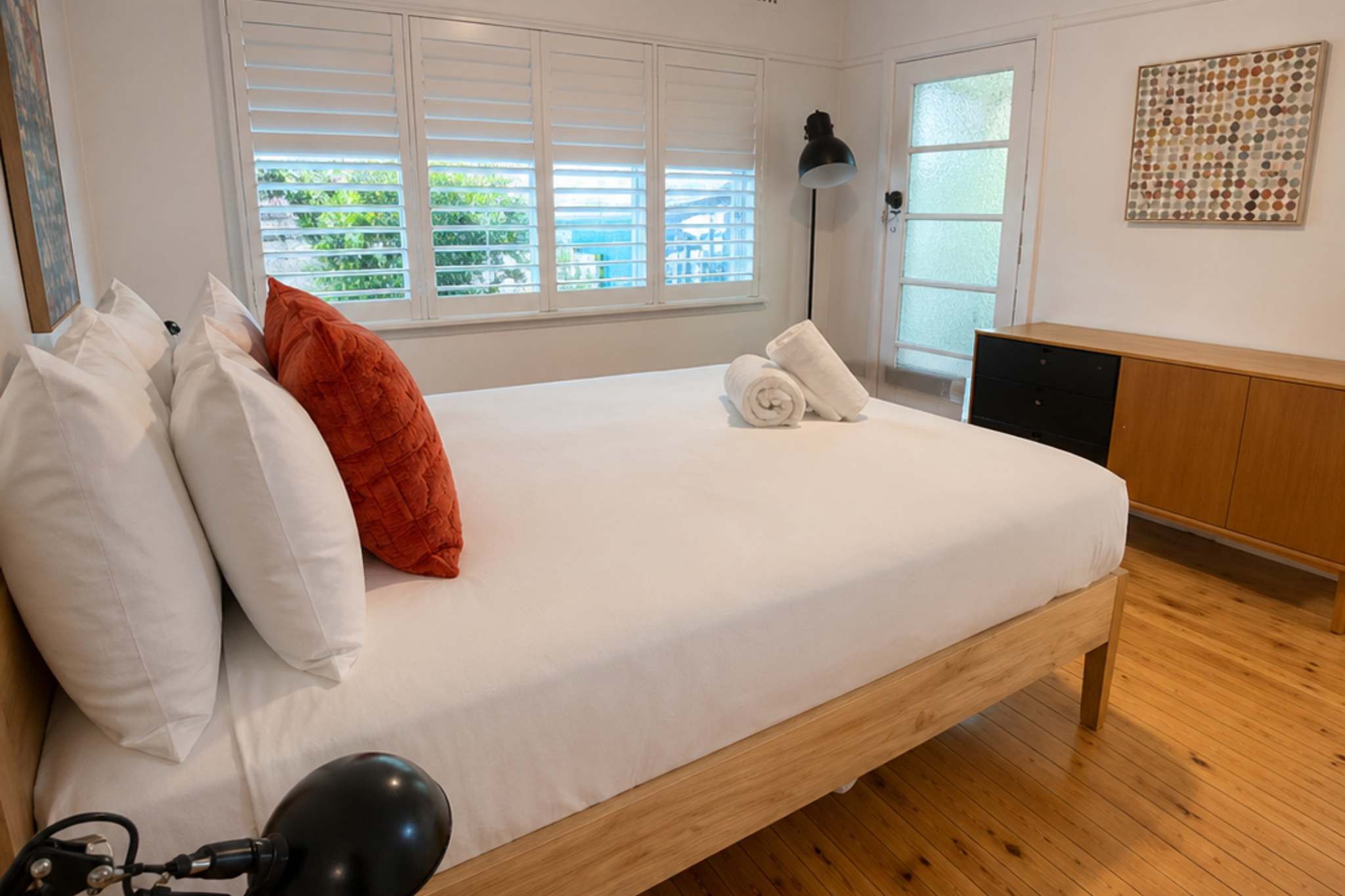 Spacious bedroom at Katoomba holiday cottage with queen bed, timber flooring, large windows and modern furnishings.