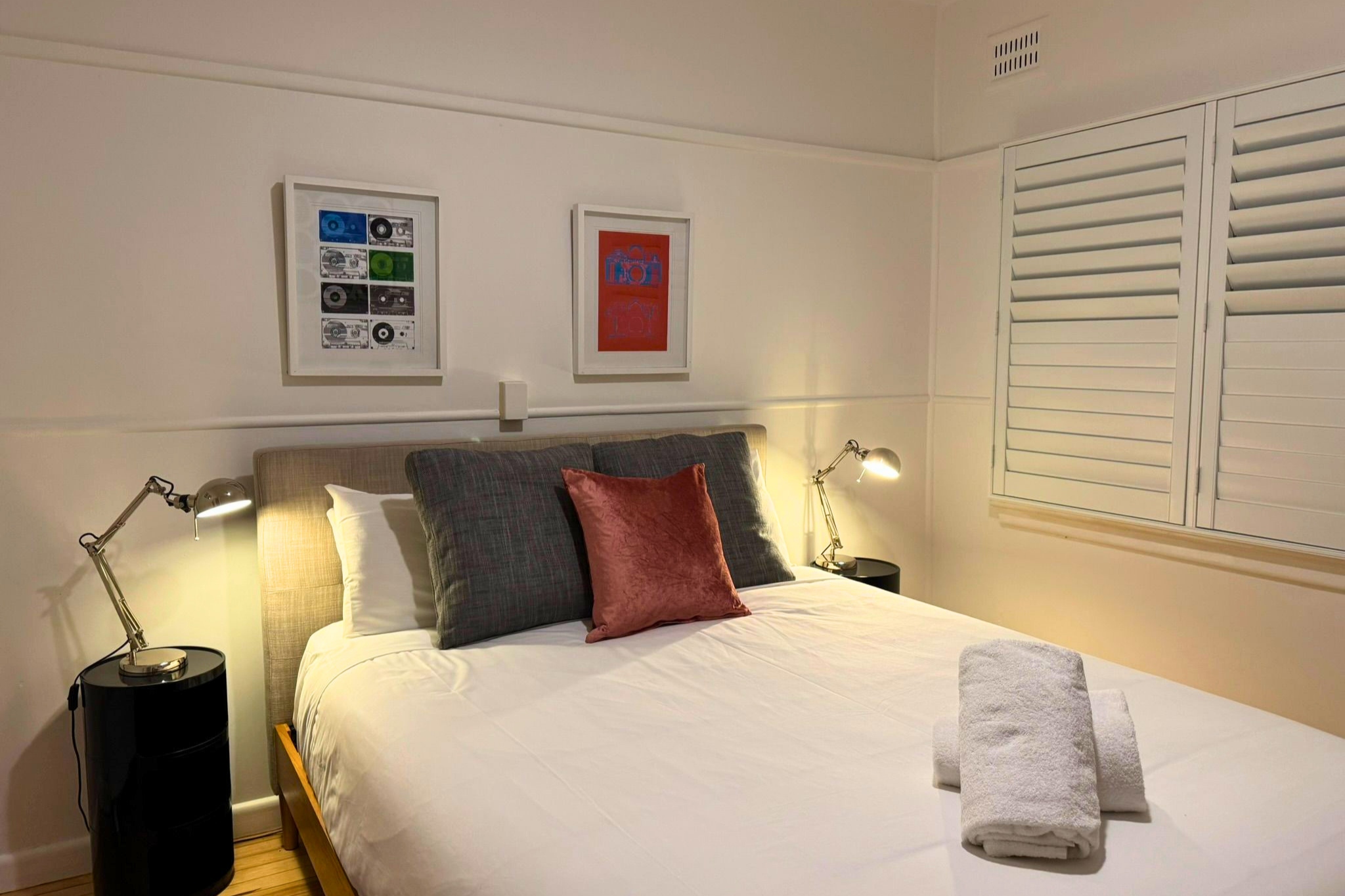 Warm and inviting bedroom in Blue Mountains holiday home with plush bedding, soft lighting and relaxed modern styling.