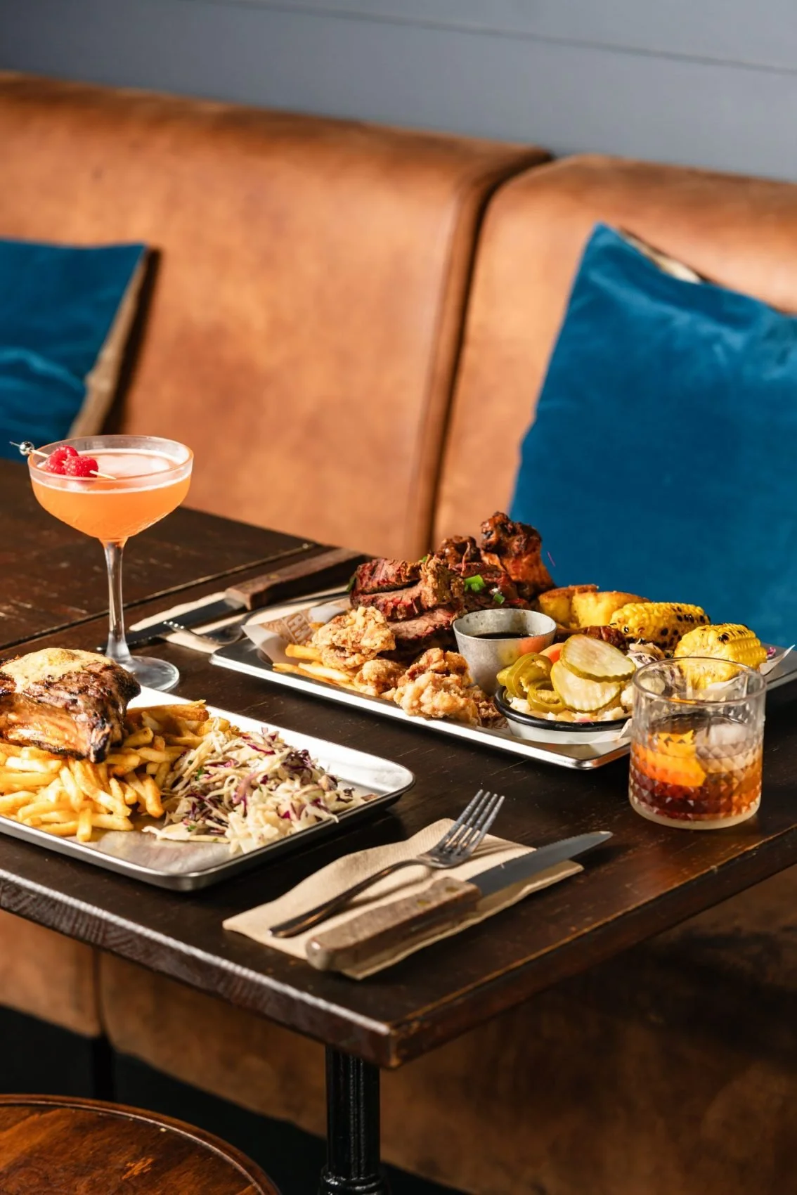 American-style barbecue platter with ribs, fries, corn and cocktails at Bootlegger Smokehouse