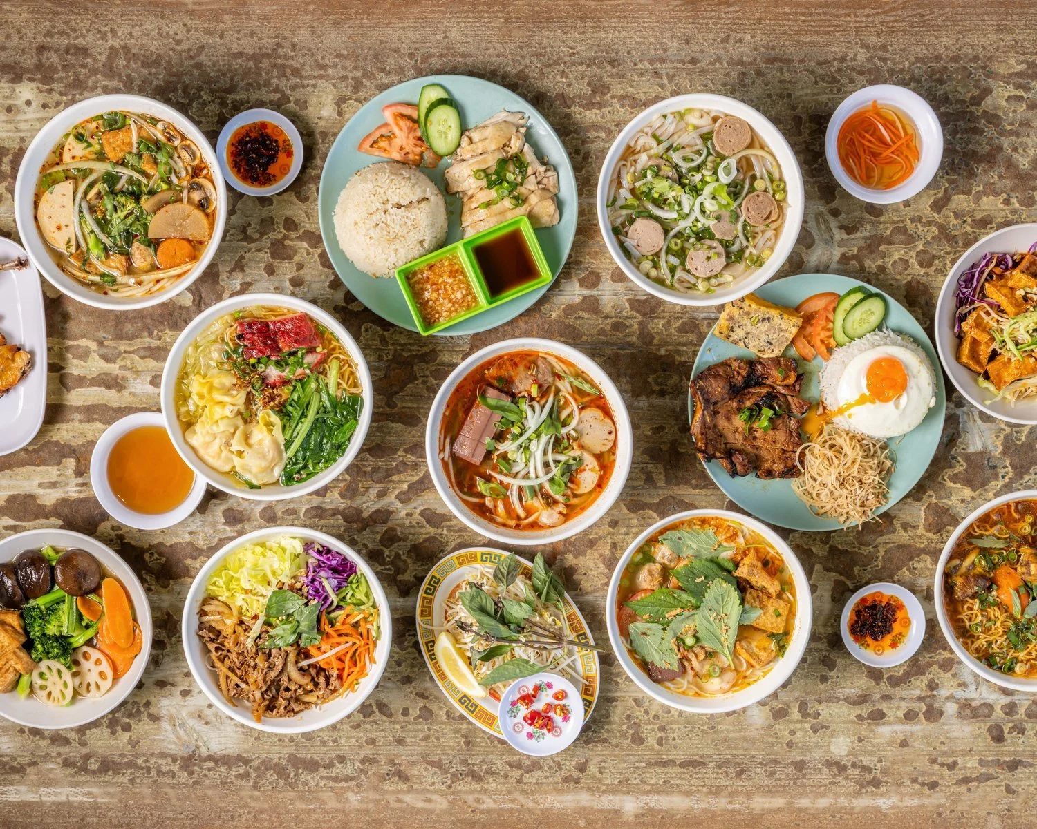 Vietnamese dishes including pho, rice meals and fresh herbs served on a table