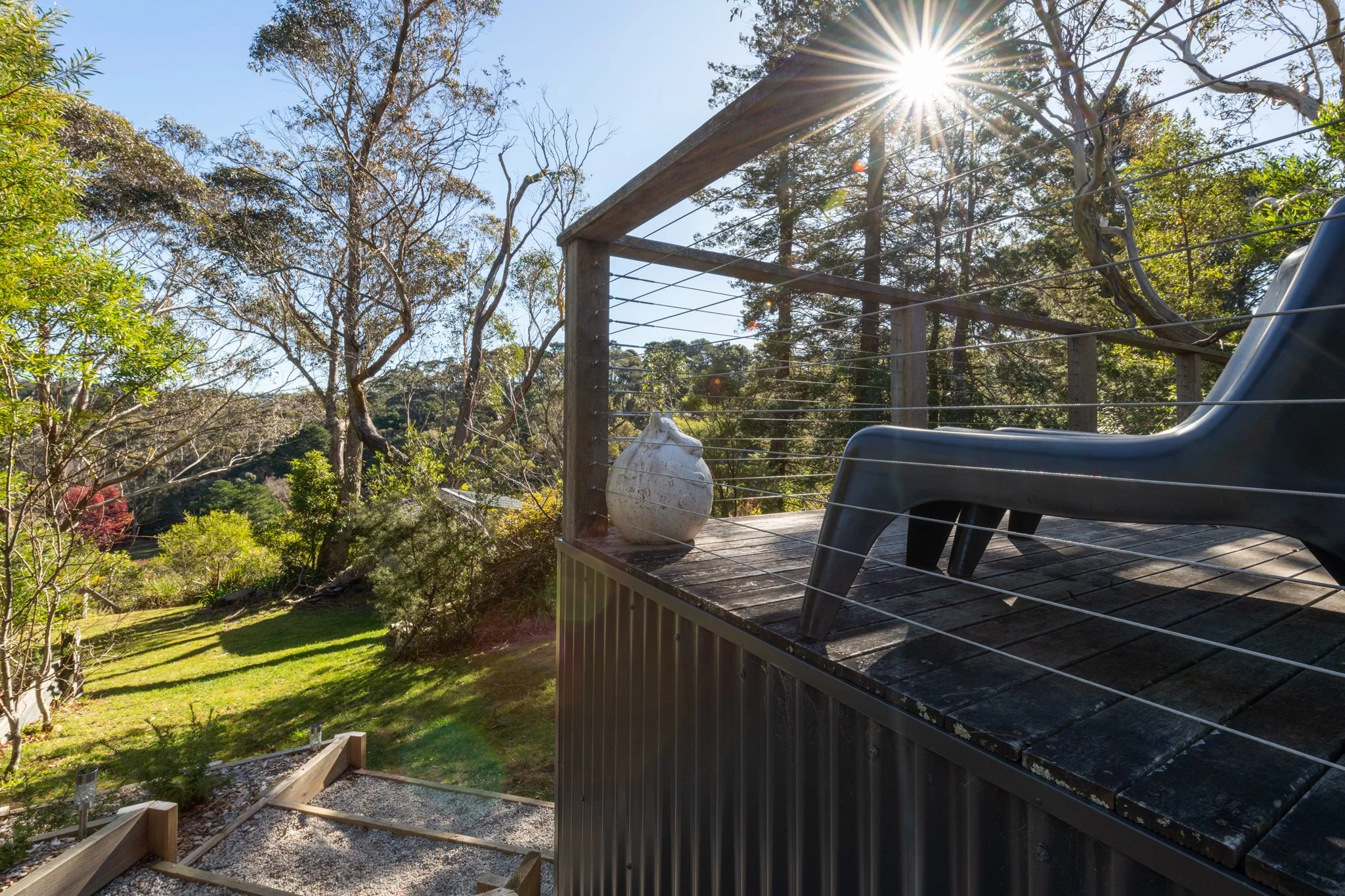 Sunny balcony at Katoomba holiday cottage with outdoor seating and bushland views in the Blue Mountains.