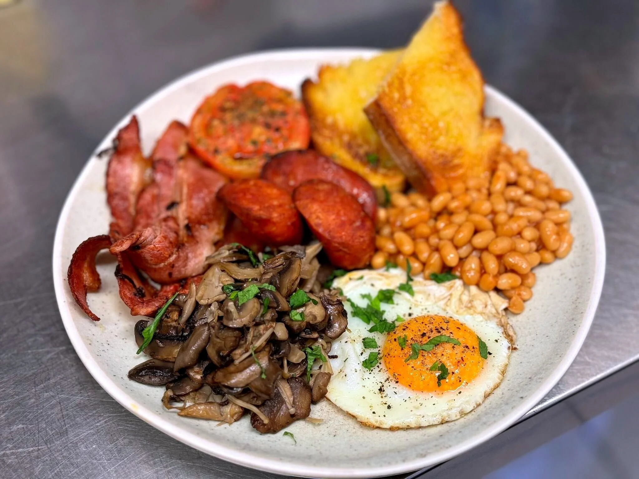 Hearty breakfast plate with eggs, bacon, mushrooms, and toast at Hounslow Blackheath