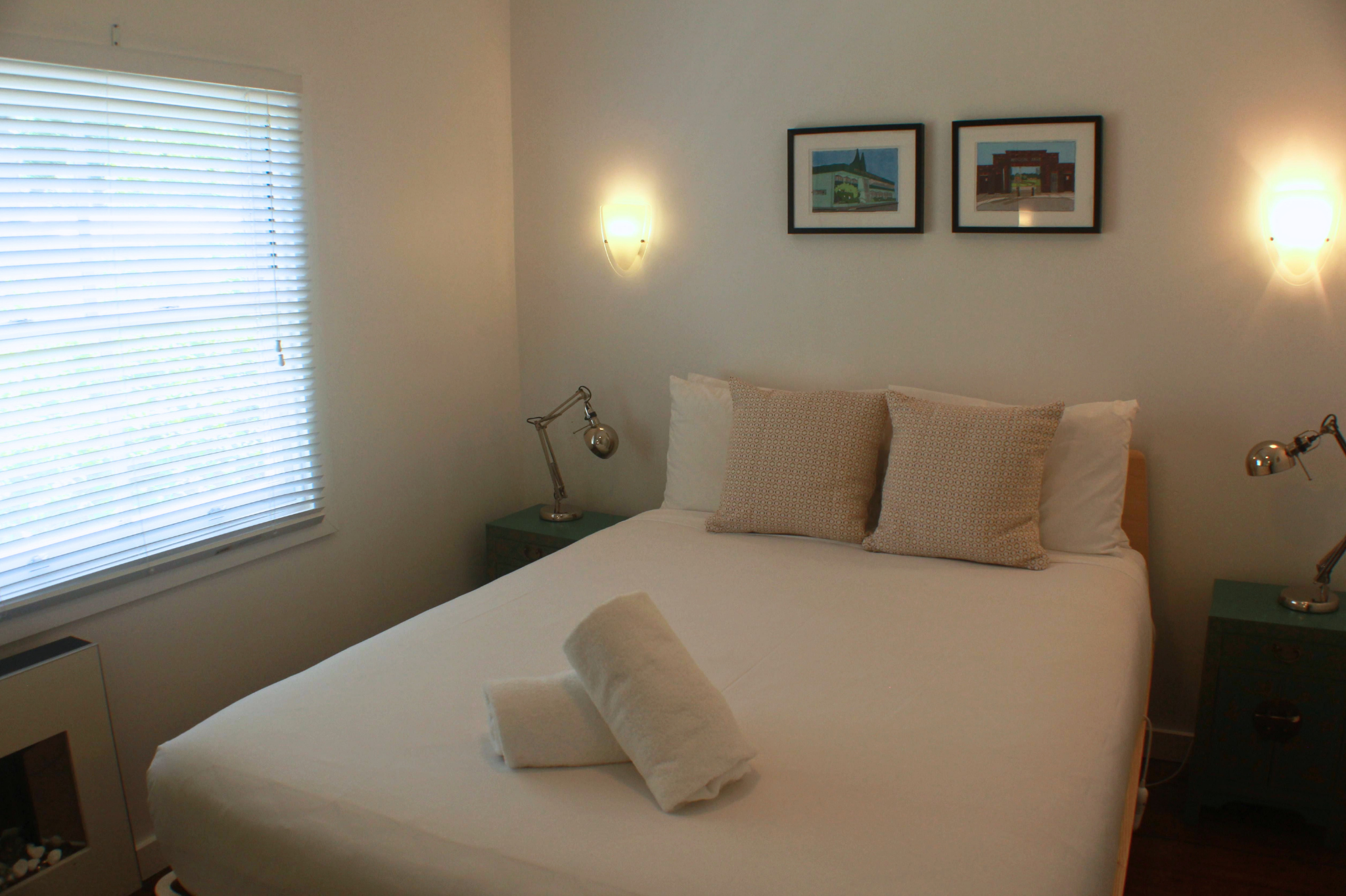 Bedroom in Blackheath, Blue Mountains featuring a comfortable bed, bedside tables, wall lights and window with blinds.