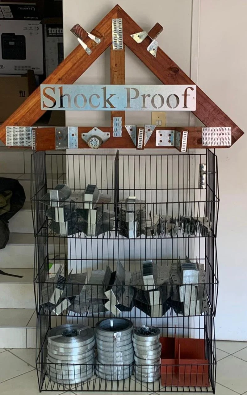 Metal connectors and brackets display with a "Shock Proof" sign on top.