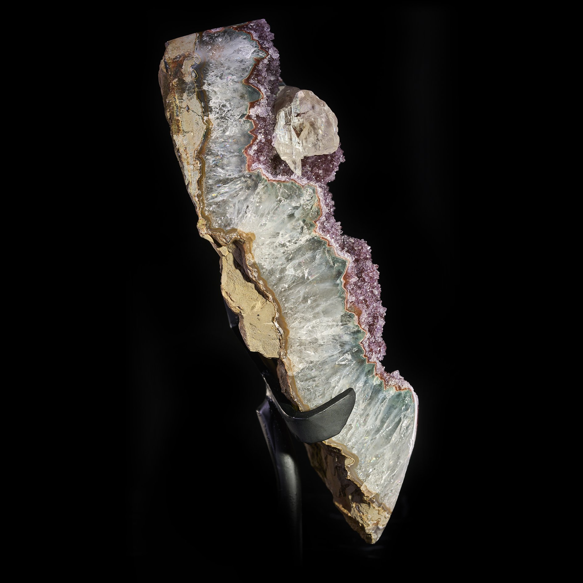 Image Description: A side angle view of a purple amethyst freeform piece with multiple calcite formations.