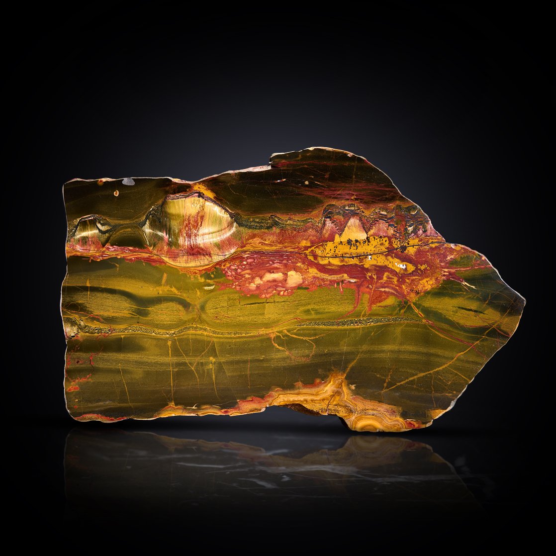 Image Description: A Marra Mamba slab showcasing fiery colors and a golden chatoyance due to the interplay of quartz and iron oxide.