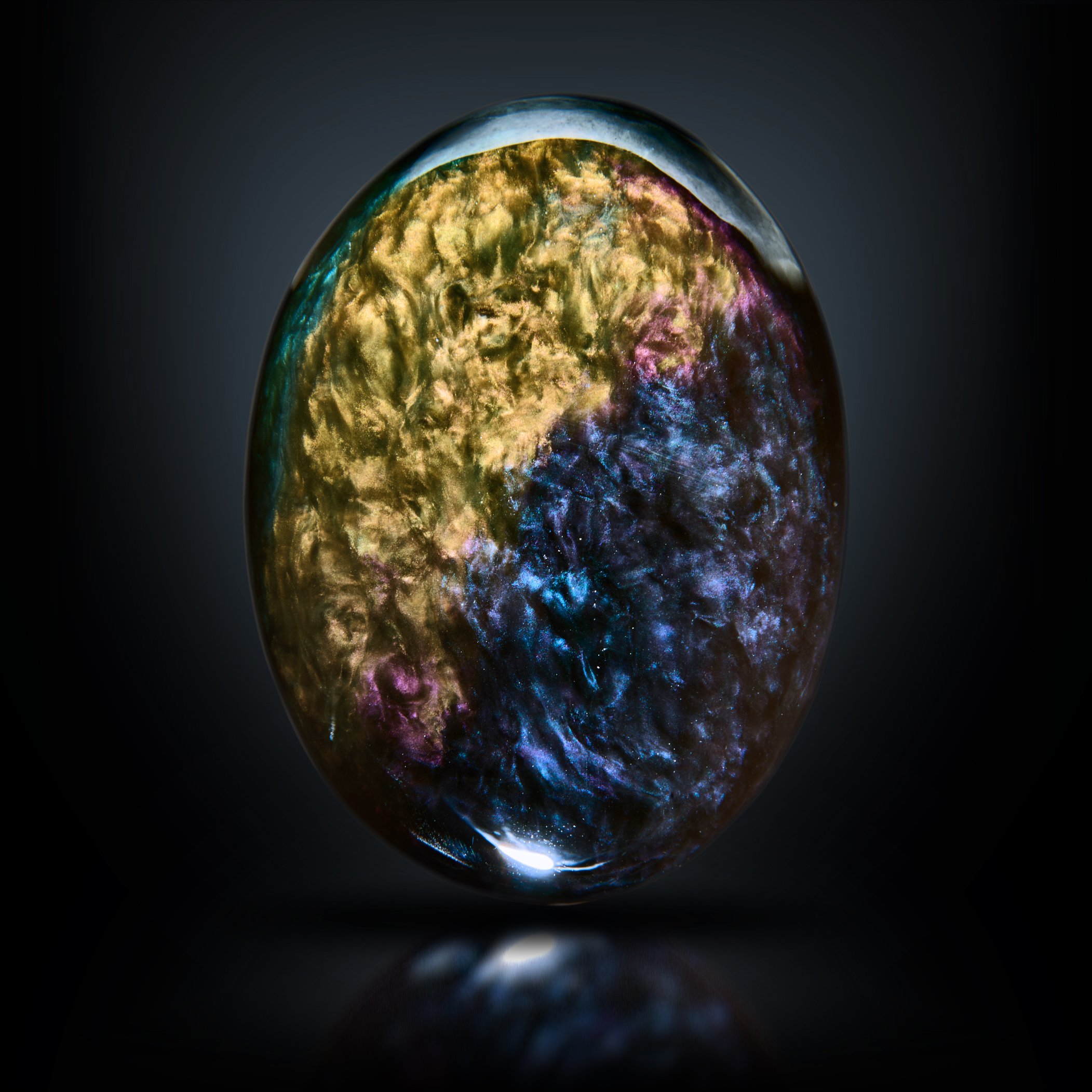 Image Description: The rear side of the velvet obsidian palmstone. The piece has a strong chatoyance with colorful hues.