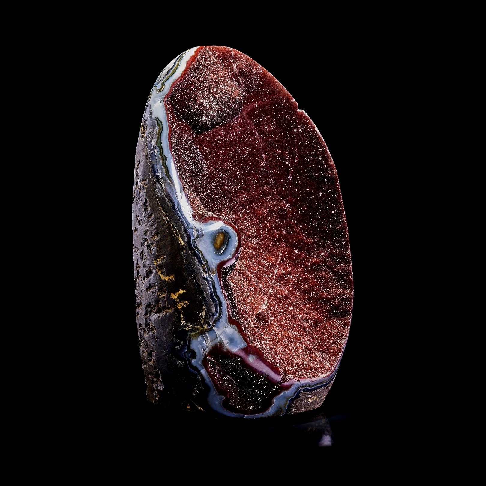 Image Description: A three-quarters angle view of a red amethyst freeform piece.