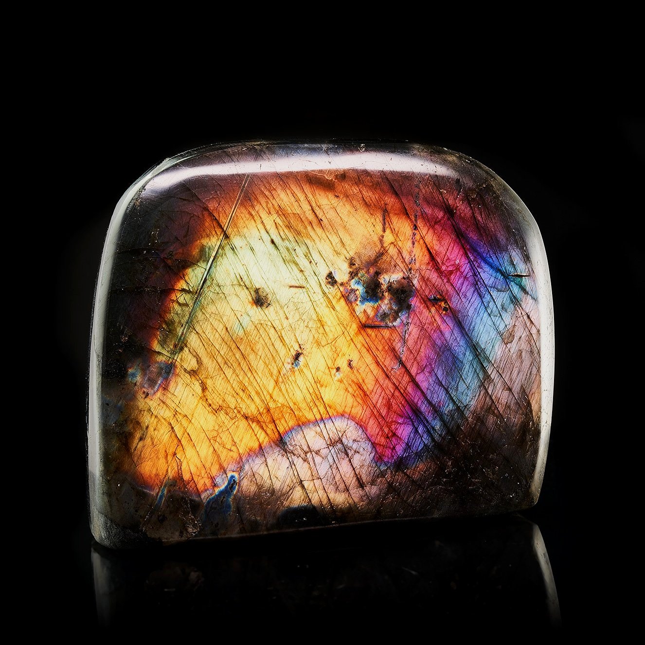 Image Description: A Labradorite Freeform piece with a bright flash of yellow, orange, purple, magenta, blue and teal color hues.
