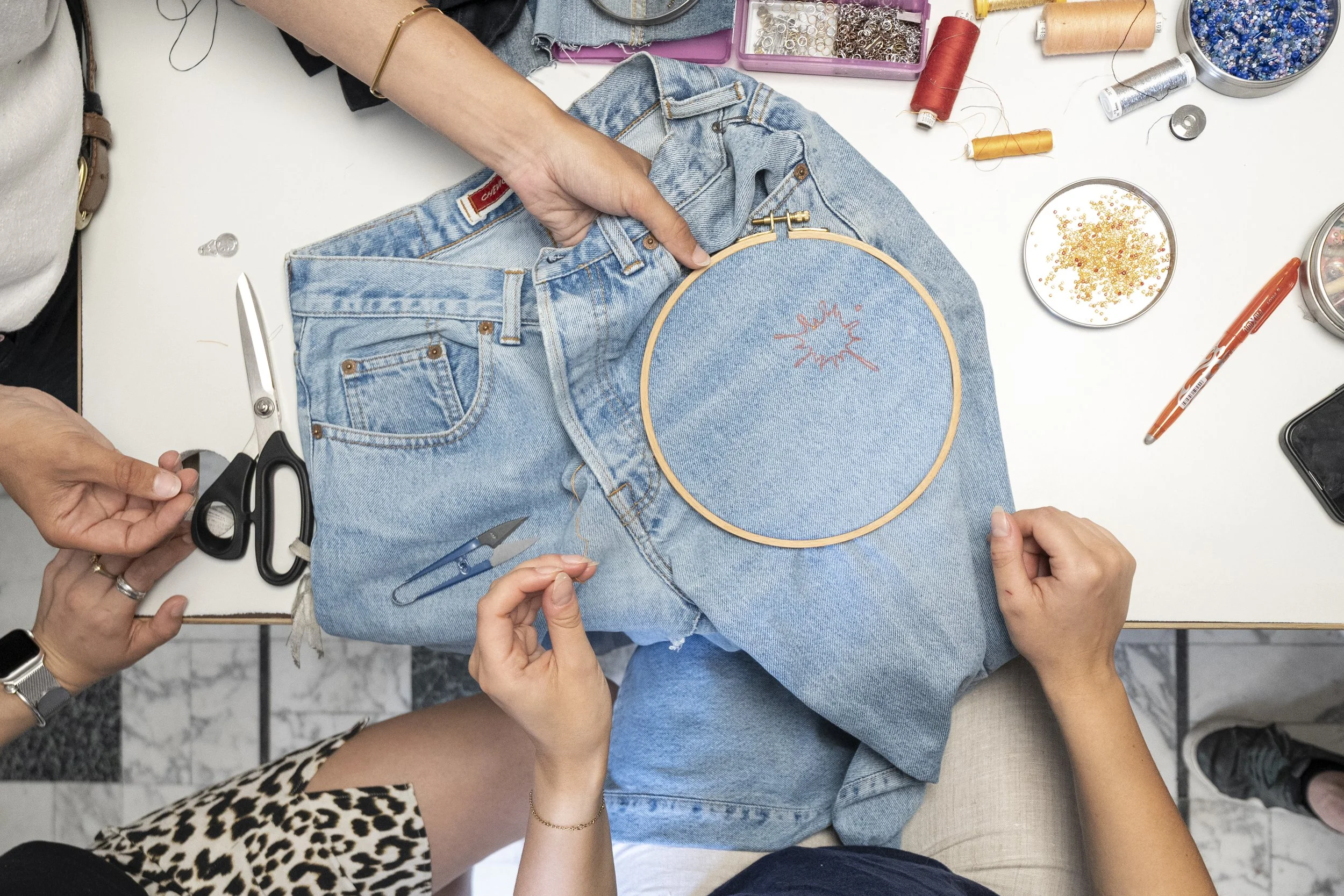 Atelier de réparation créative et broderie sur jeans upcyclé chez L'Unique Façon, laboratoire textile à Nantes.