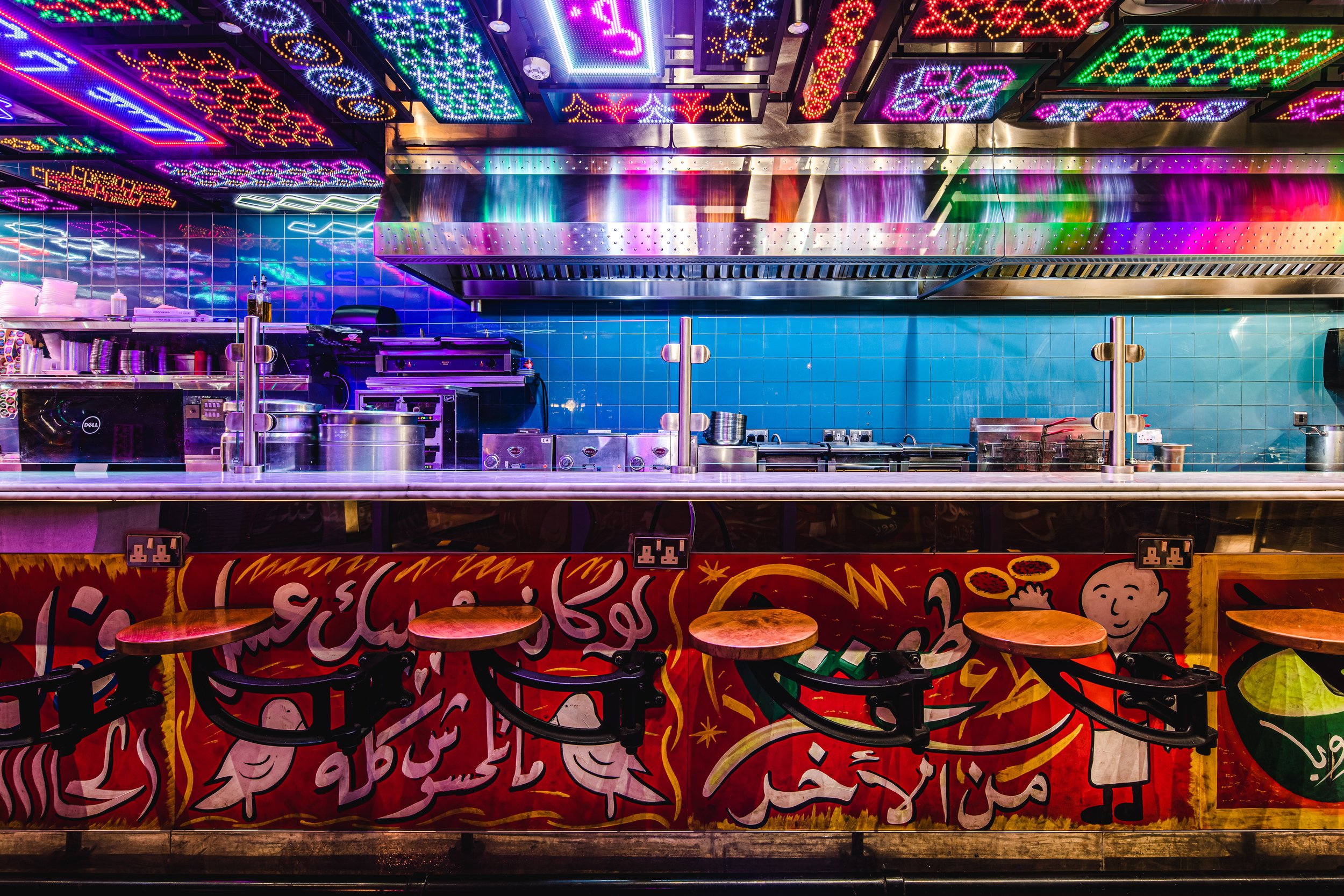  View of the eat-in counter detailing the custom fabricated illuminated soffit and the hand-painted “ful cart” panels. 