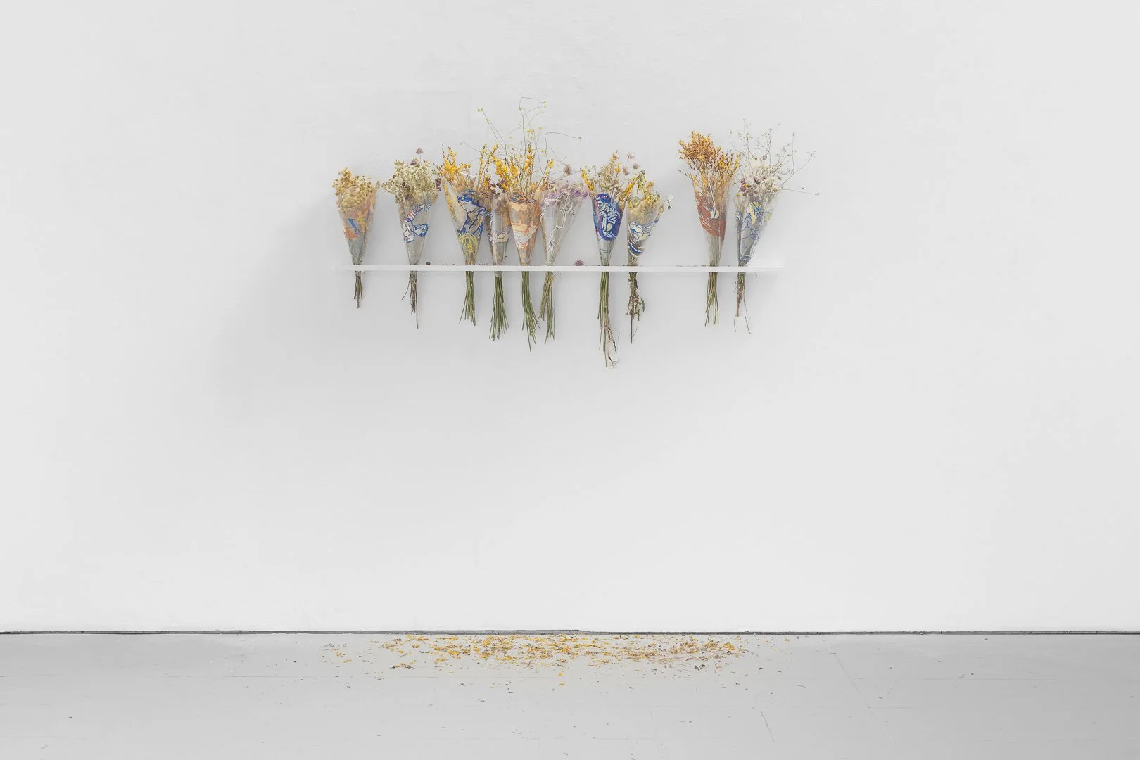 João Carinho, Flores para o Mausoléu (Barreiro). [Flowers to the Mausoleum (Barreiro).] Ten bouquets of wildflowers
wrapped in acetate sheets with marker drawings, 150w cm × variable dimensions, 2026.