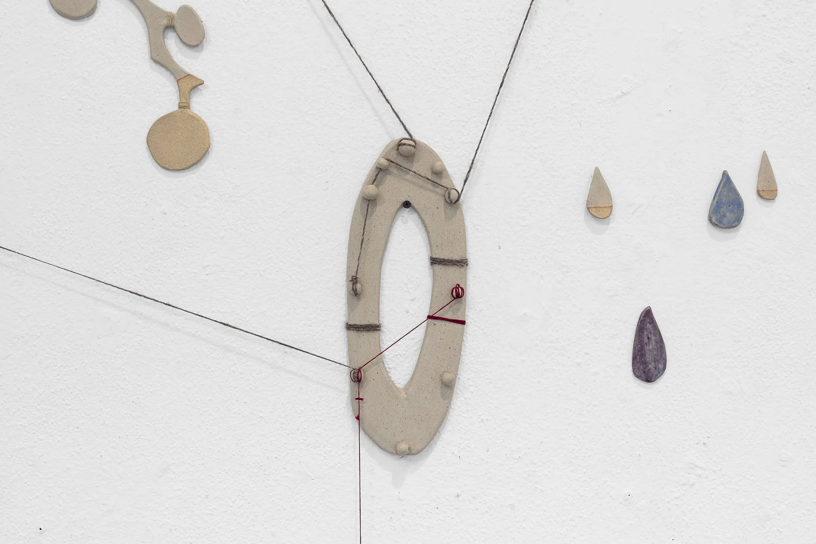Marta Troya, Heart–Throat Constellation. Ceramics, wool and cotton thread, dyed canvas. Wall installation, 2026