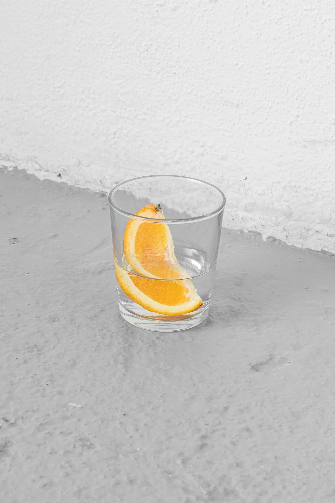 Silvia Koistinen, the smallness of things. Mandarins, wire basket, plate, shelves, glass with water and orange slice, miscellaneous glasses and cups, cloakroom tickets with text, bonbon wrapper, variable dimensions, 2026.