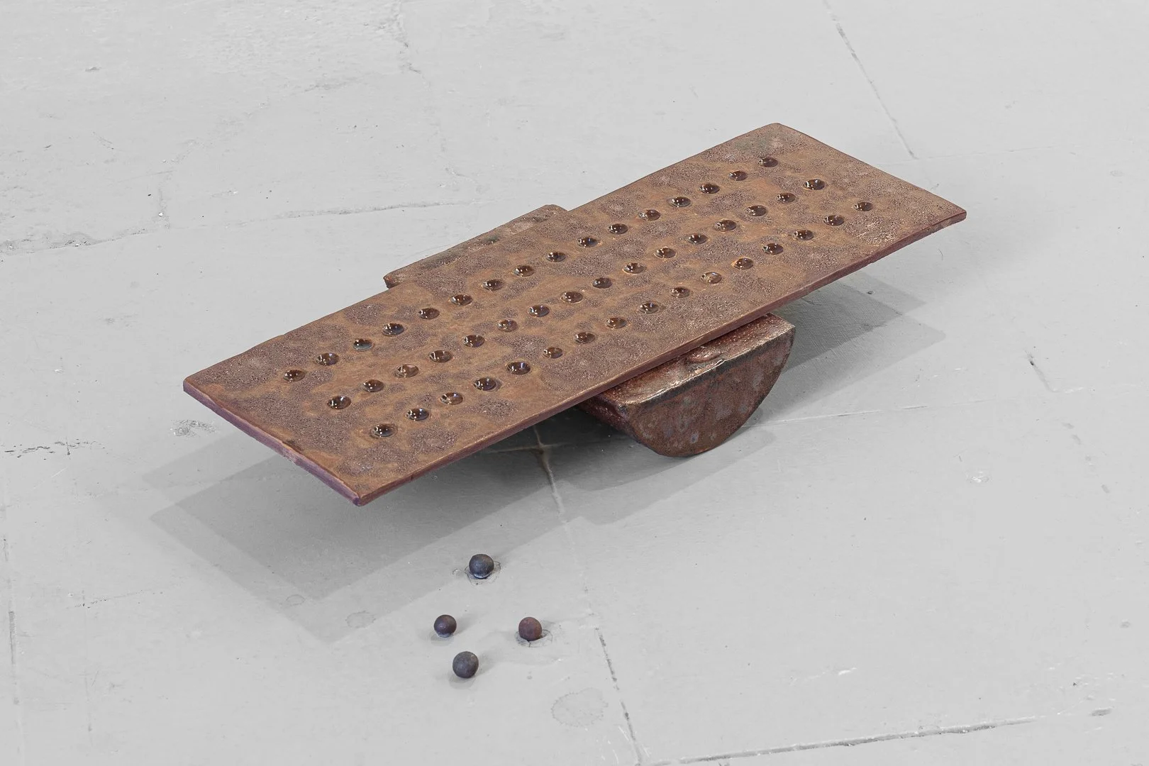 Gaia D’Arrigo, The fool’s playground. Ceramic, industrial waste glaze, unknown spheres, Pyrite 60 x 30 cm, 2026
