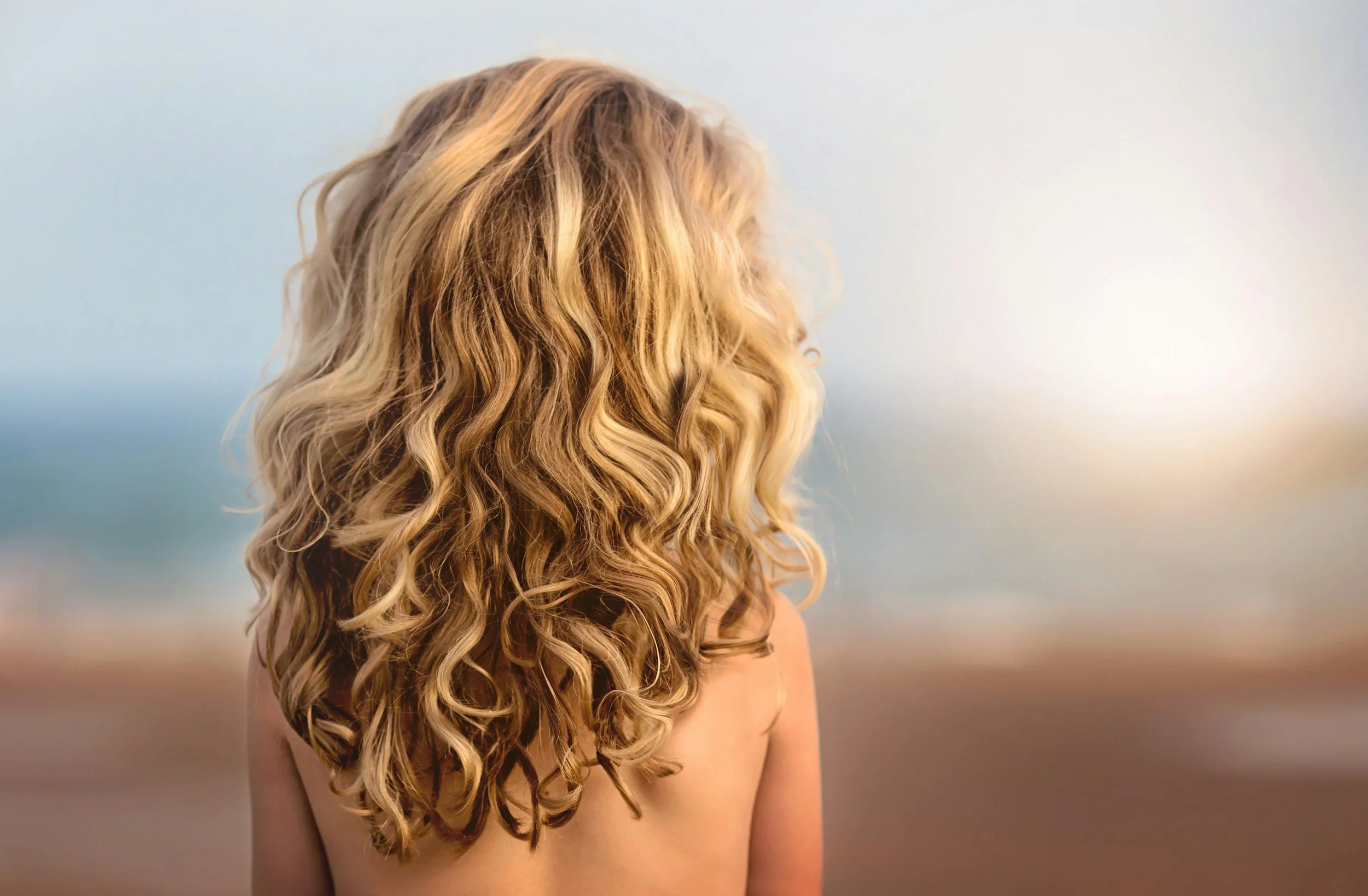 Long wavy blonde balayage hair, an example of colour work at Blunt Hair Studio Kingston