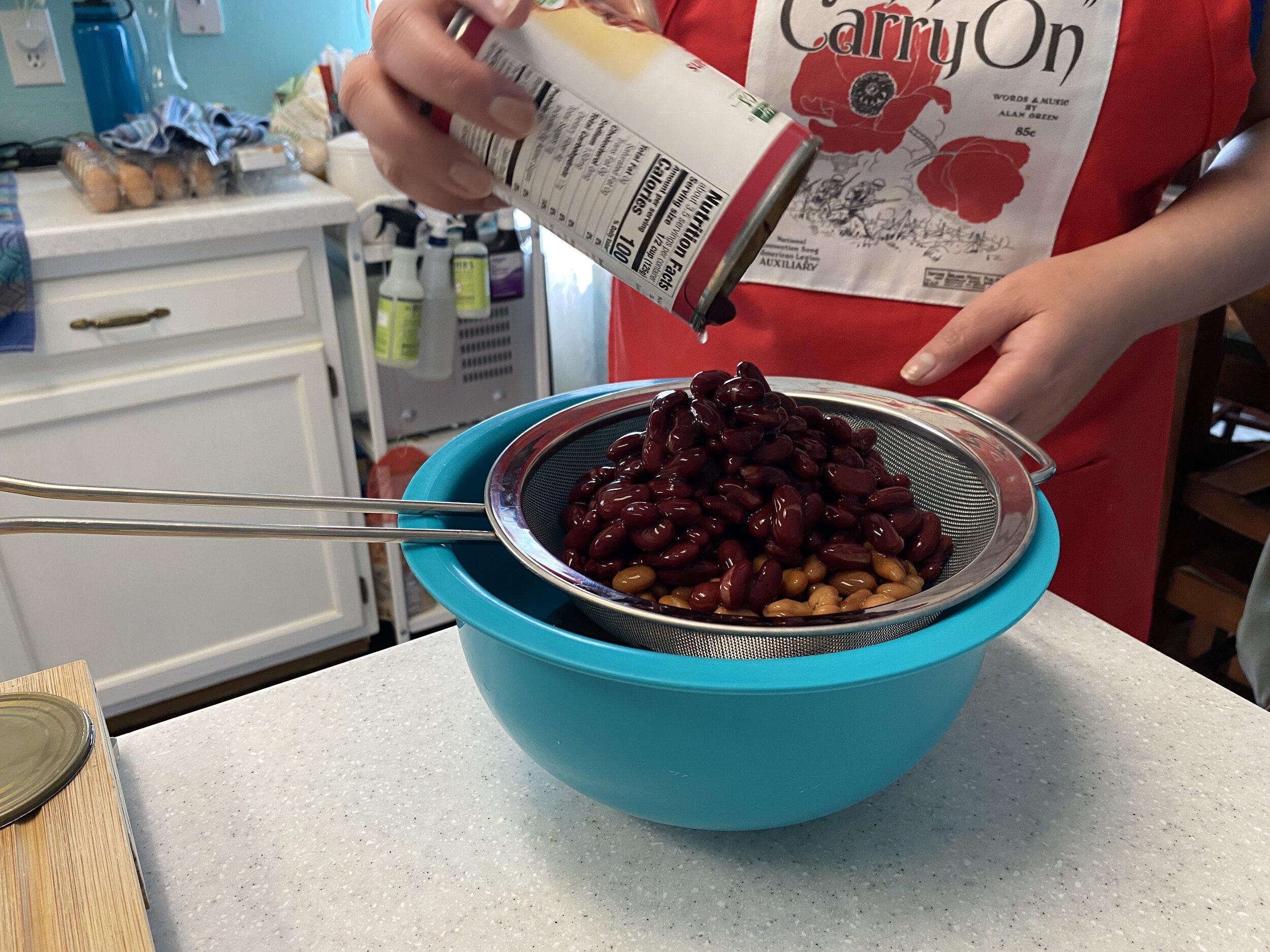 While the chili is coming to a boil, go ahead and prep the beans. I like to pour all three kinds of beans into a strainer and then rinse really well under running water.