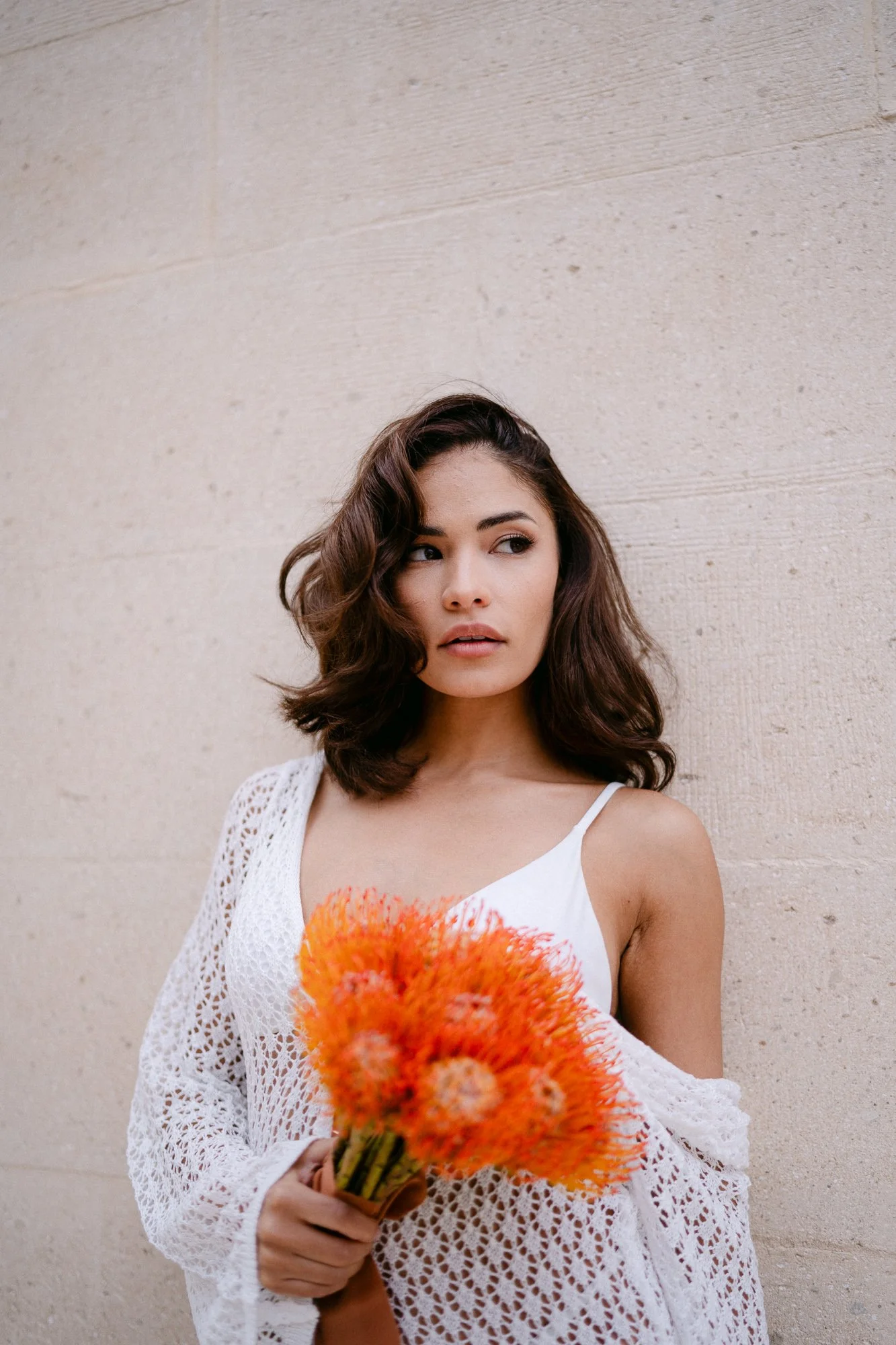 Woman holding large orange protea flower — editorial wedding photography Tuscany