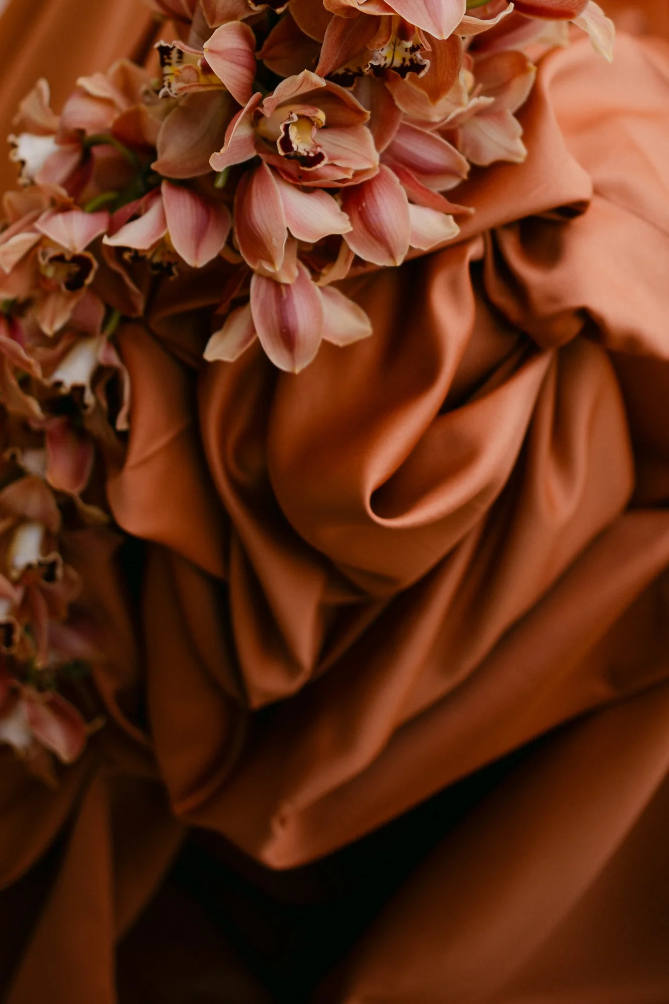 Close-up of burnt orange silk fabric with flower — editorial detail photography Tuscany