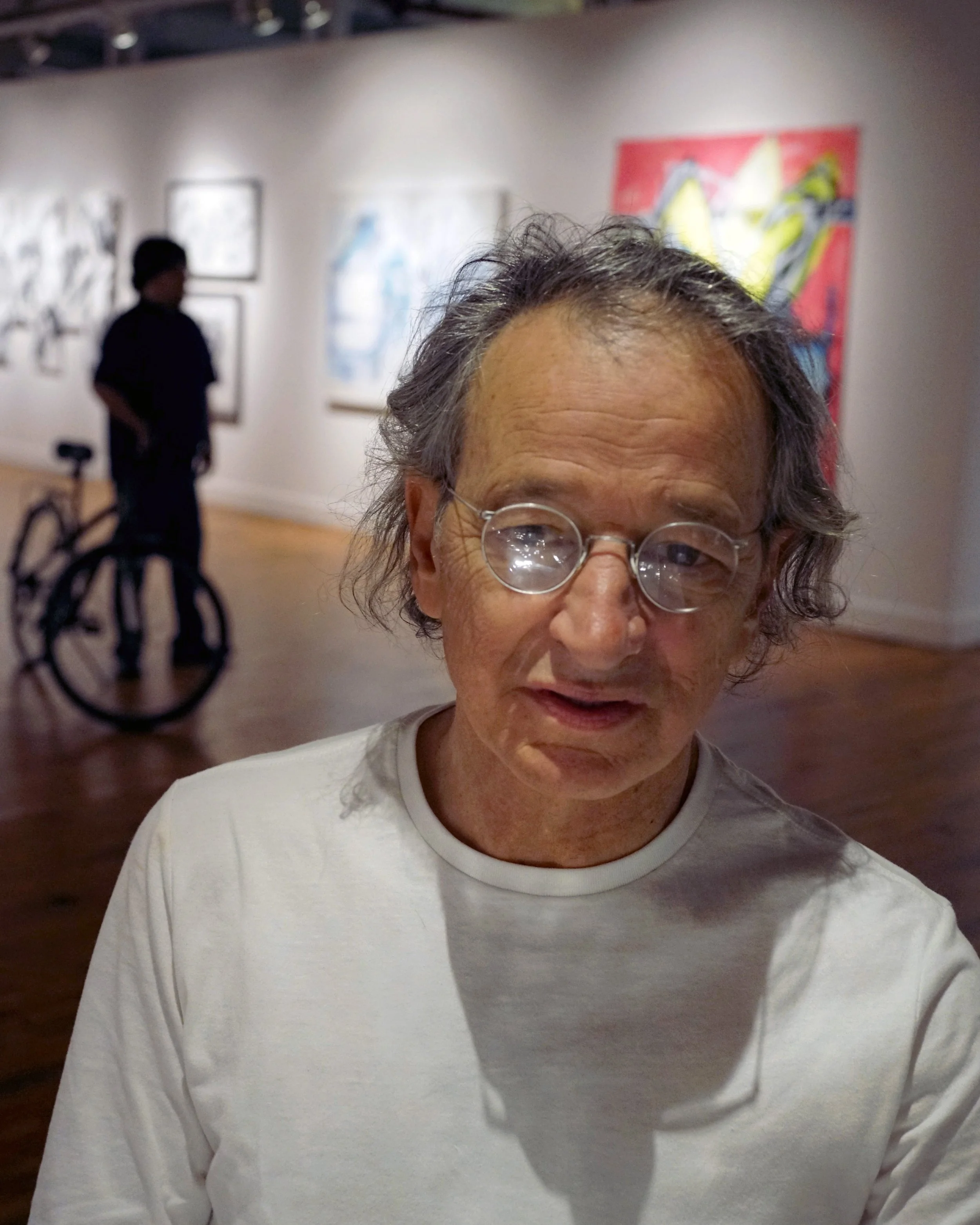 John Pagano in Sprinkler Factory with silhouette of man and bike in the background by Stephen DiRad