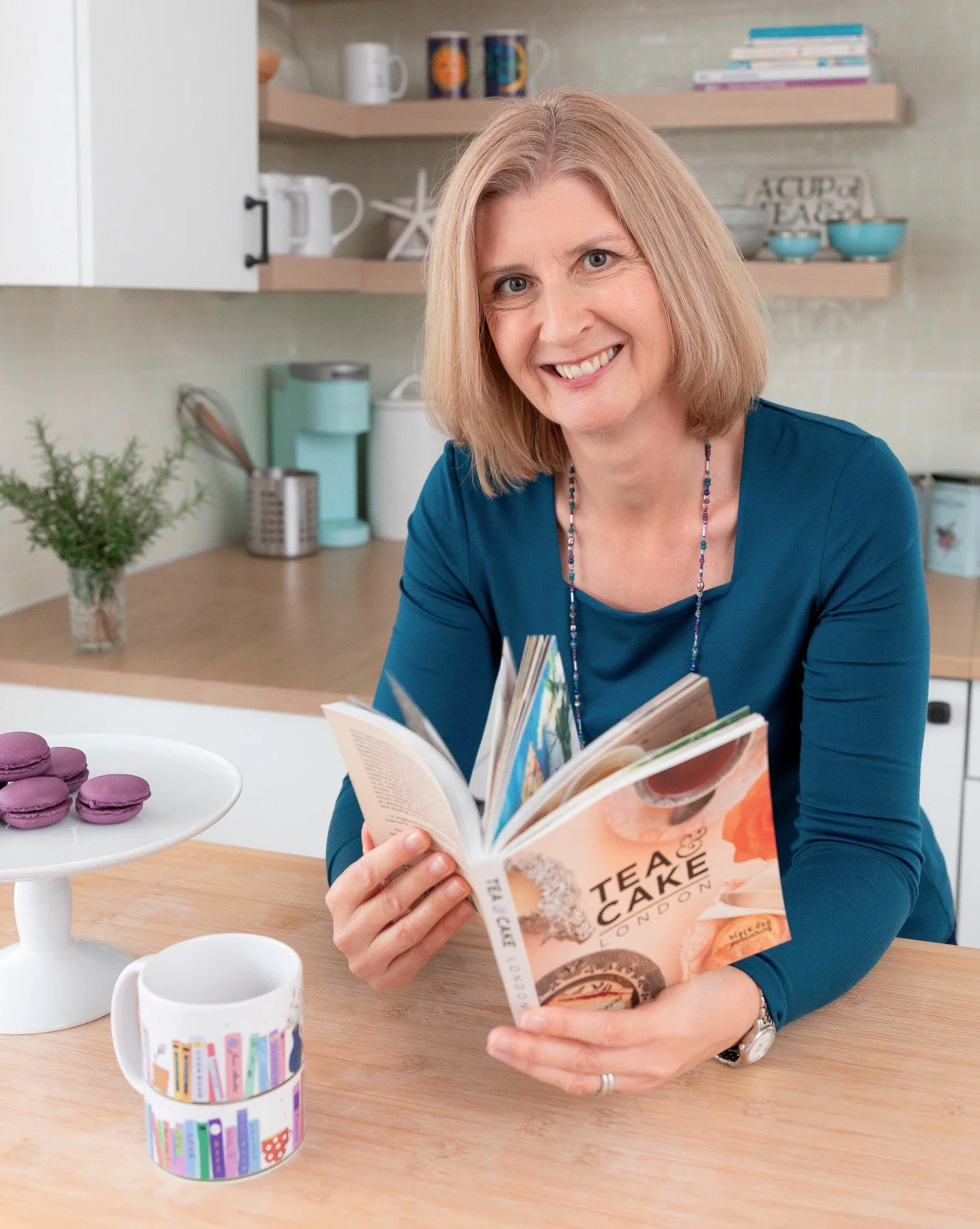 Pauline Wiles in the kitchen with a book
