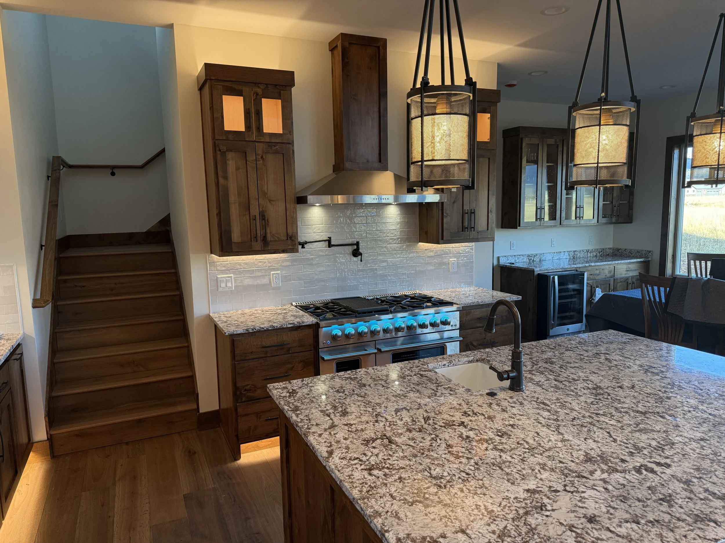 Custom kitchen with granite countertops, large island, and wood cabinetry in a luxury Driggs 
custom home..