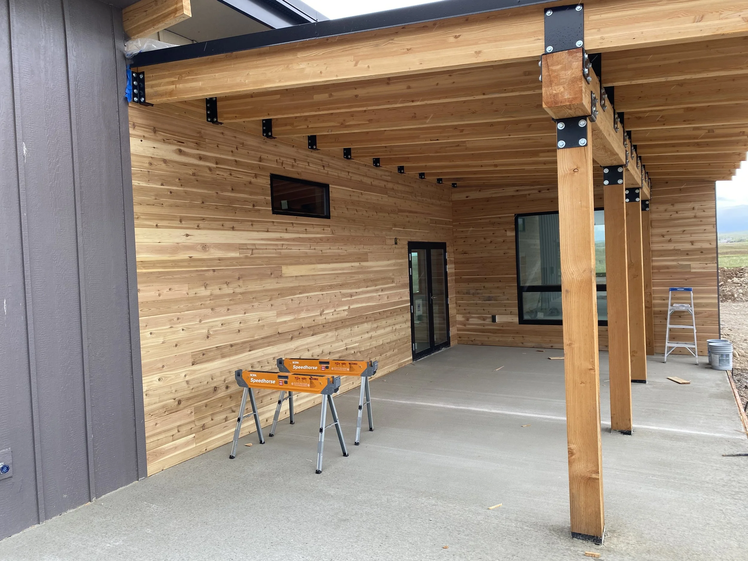 Covered outdoor patio with timber beams and natural wood siding in Teton County, Idaho