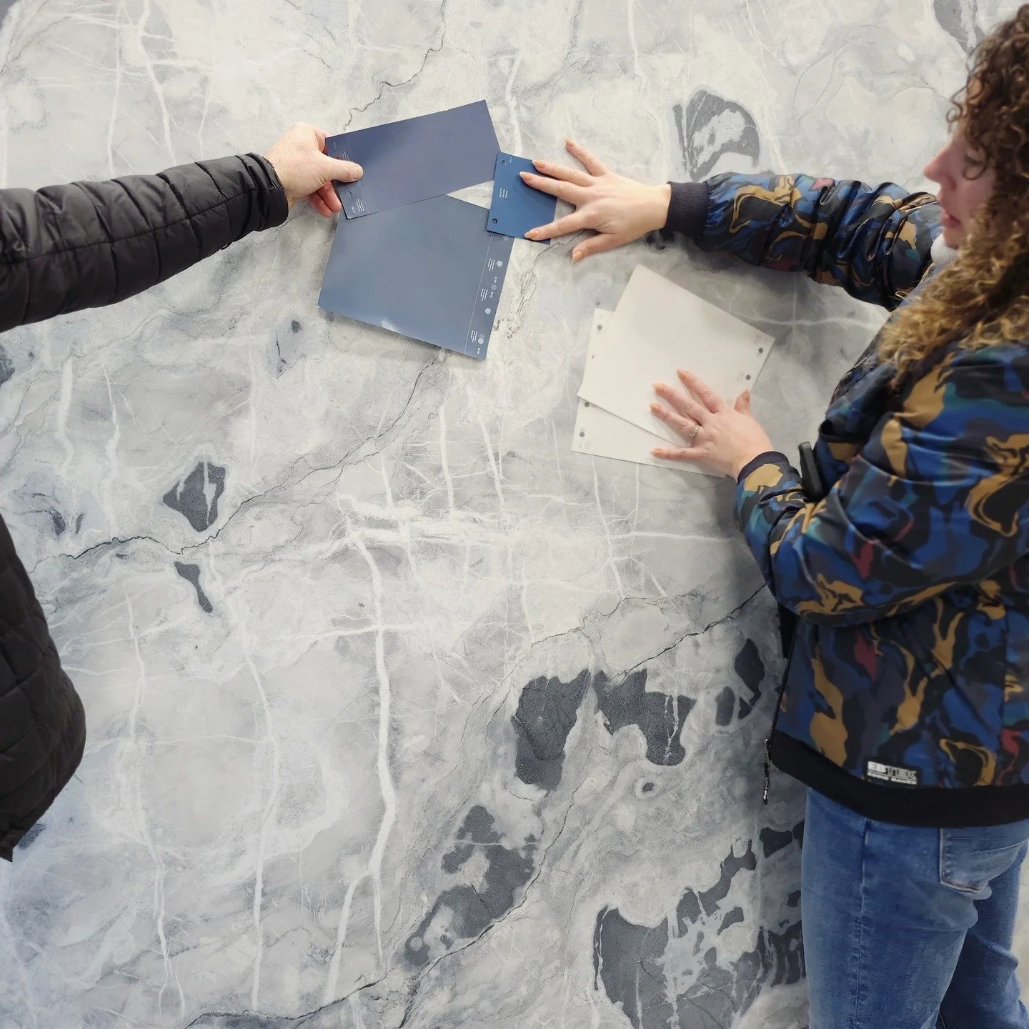 Field Trip. Countertops. You have got to see it and you have to feel it. Tones matter - including whites! 
These clients want a three tone kitchen with white, blue and wood. They also love these highly patterned natural stones and quartz. Cohesive to