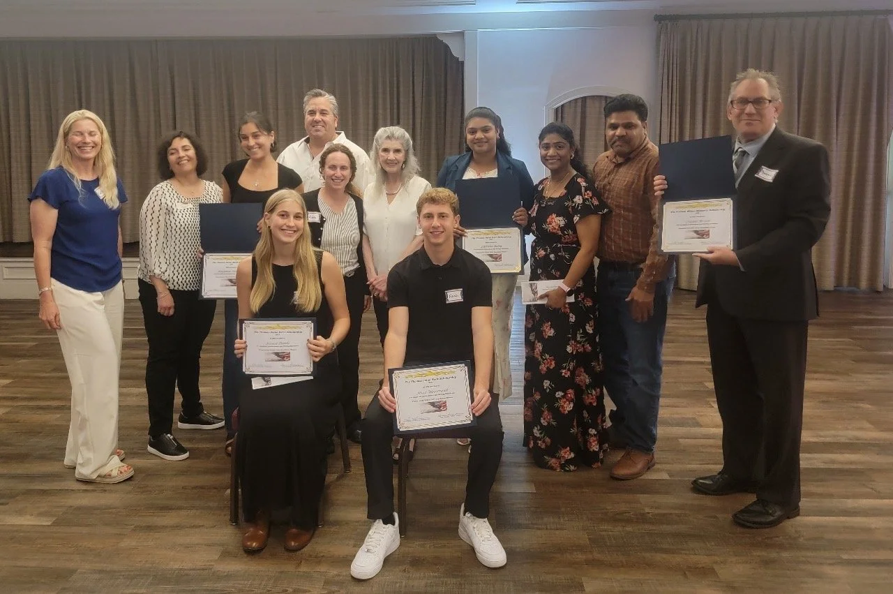 Group of people at an awards ceremony, with some holding certificates.
