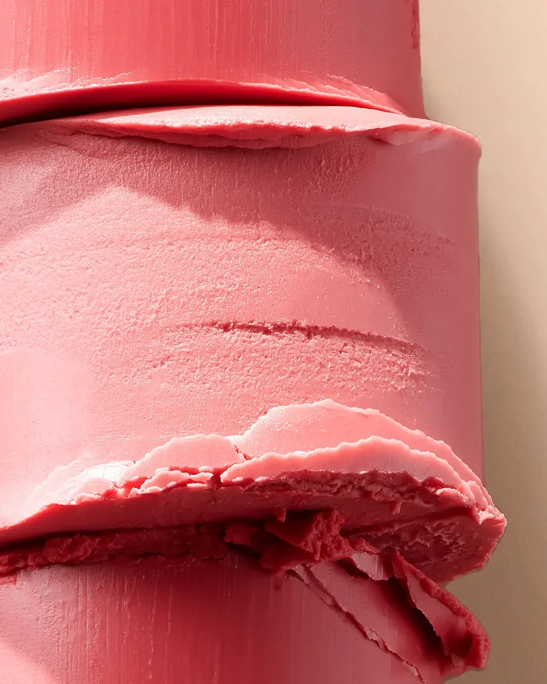 Close-up of a pink statue of a person's face, focusing on the lips, with detailed textures on the skin surface.