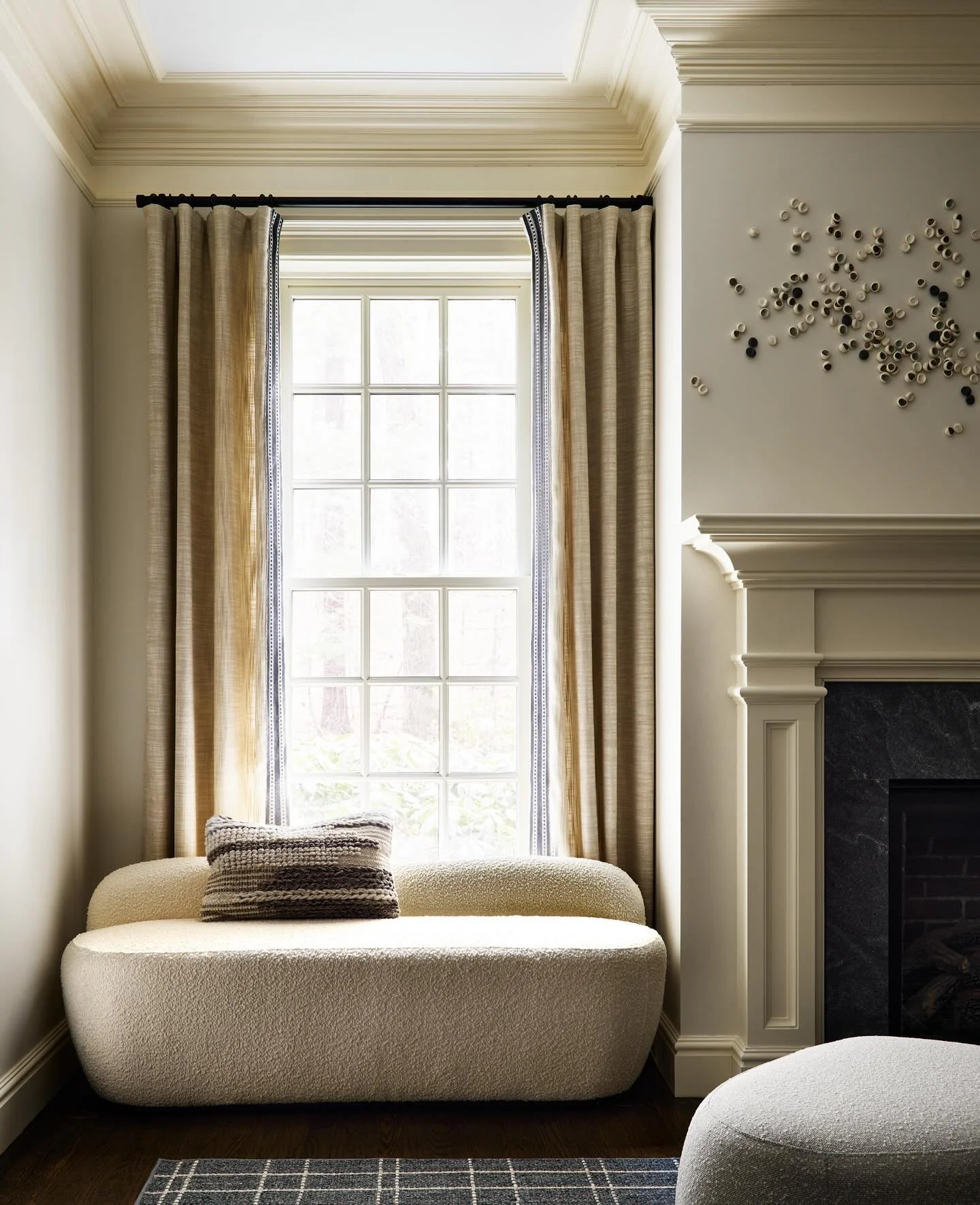 In this living room, we carved out the perfect fall retreat by the fireplace - a place to curl up with a book or watch the leaves change outside.

The sculptural bench anchors the window alcove while the organic wall installation adds movement withou