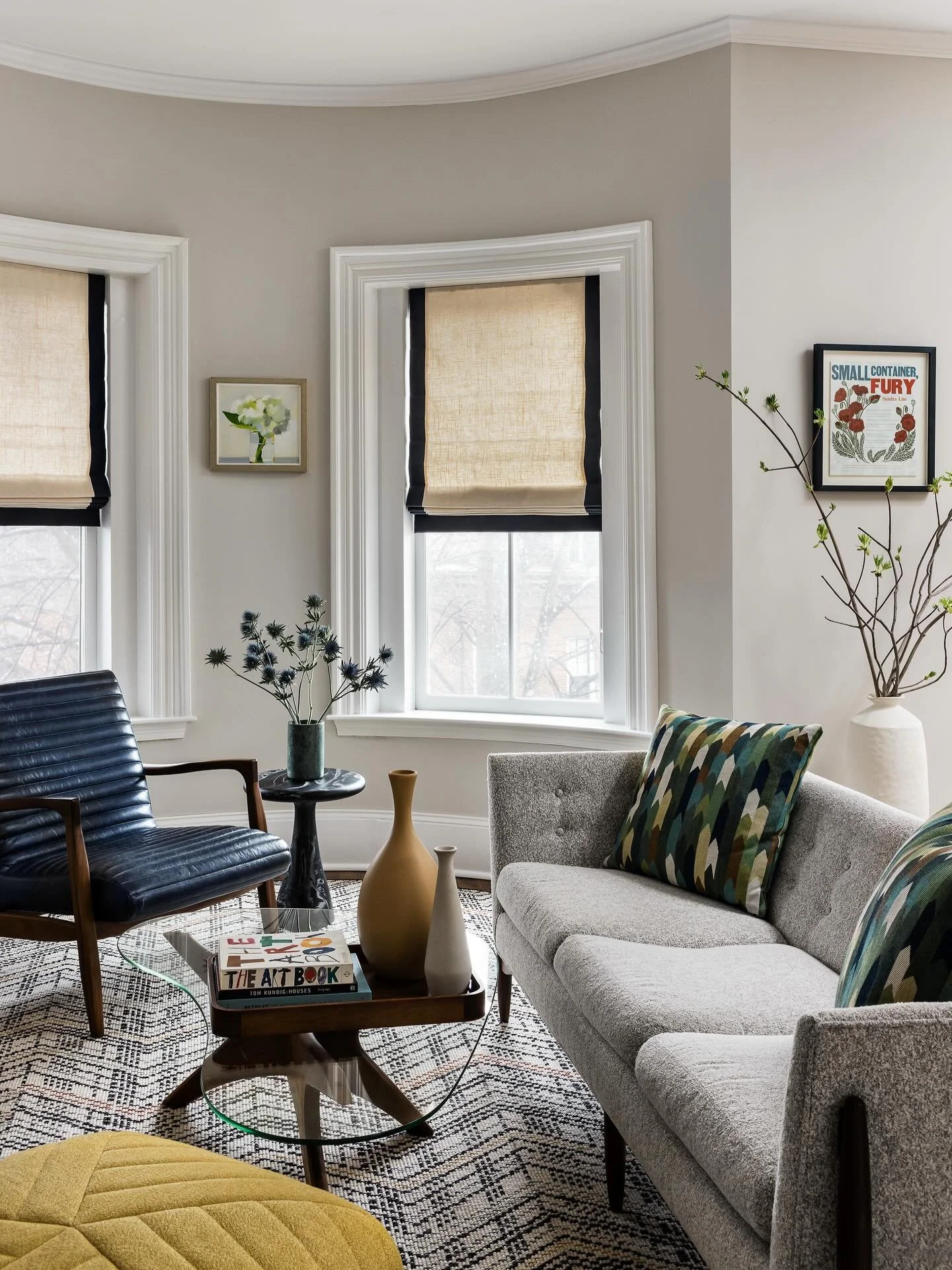 Walnut legs on the sofa, the chair, the table. A quiet through line that ties the whole room together. A rug that follows the curve of the bay window, grounding everything in place. Mid-century bones, South End light, nothing accidental.

📷 @joyelle