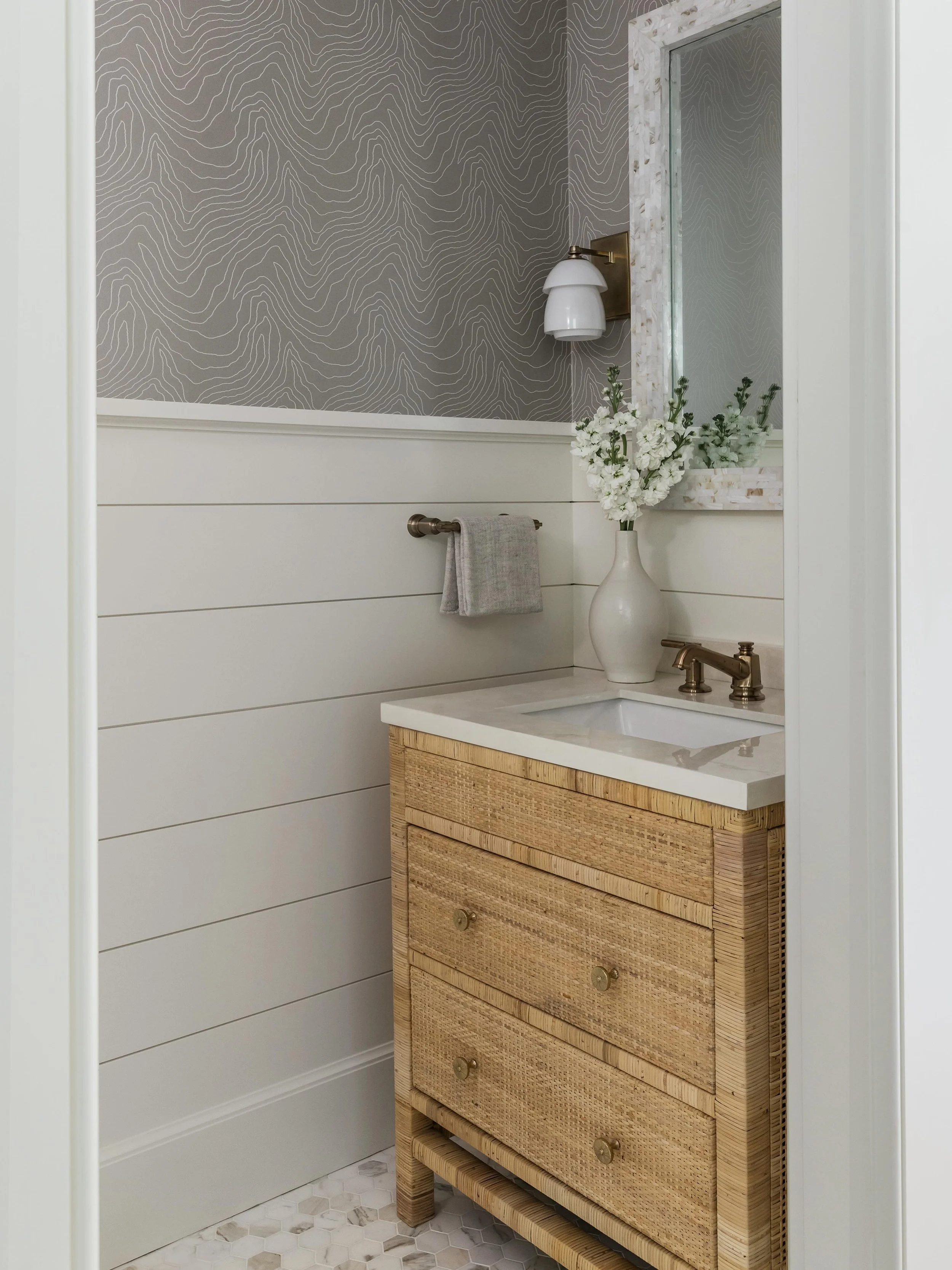 Real coastal powder room vibes&hellip;no anchor motifs required. A rattan vanity, topographic wallcovering, mother of pearl mirror, and hex tile floor doing all the work. Coastal doesn&rsquo;t have to announce itself.

📷 @joyellewest 
✨ @seanwilliam